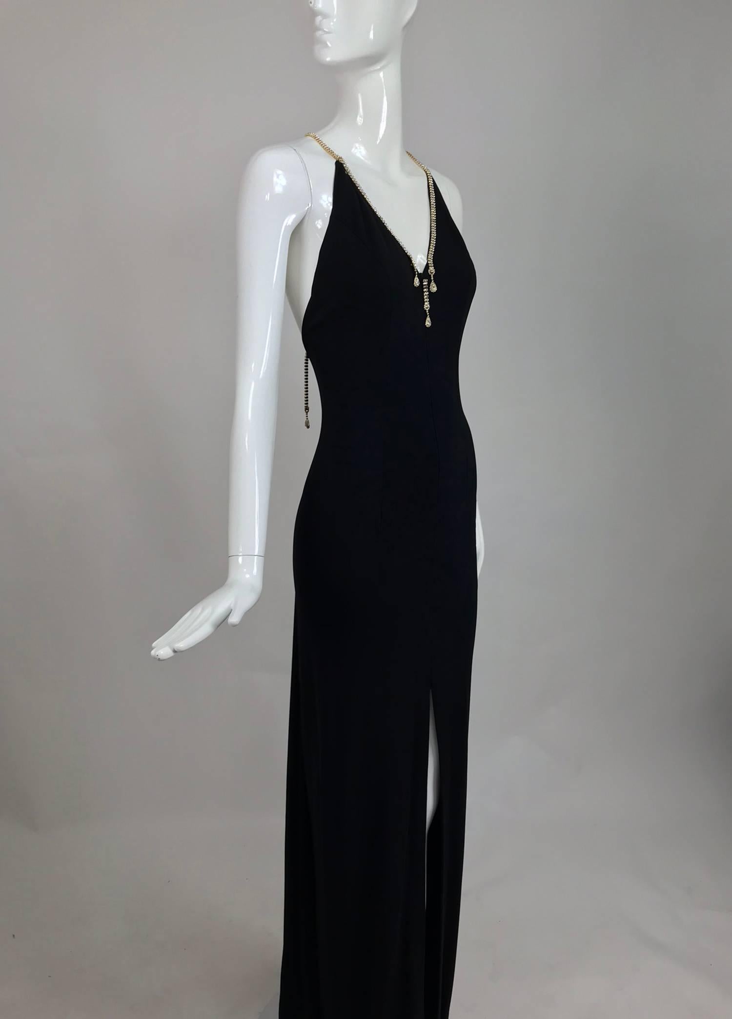 Jiki Monte Carlo evening gown of black matte jersey with Swarovski crystal straps at the plunge back and shoulders, the crystals are prong set in bright gold...A spectacular dress for a special occasion...With a plunge neckline, the dress closes at