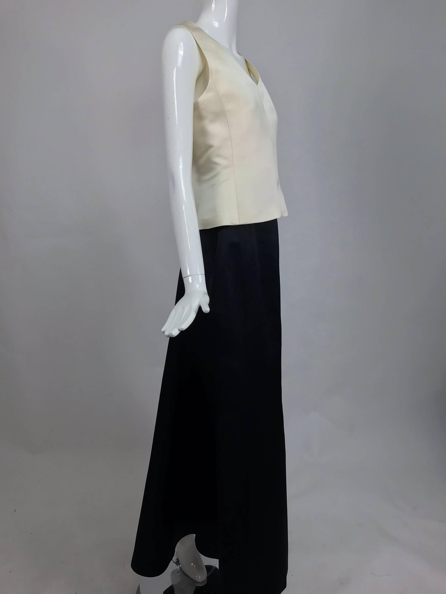 Vintage Bill Blass evening skirt set in cream and black silk satin from the 1980s. Sleeveless princess seamed v neck top is fitted through the waist and flares at the hip, it closes at the back with a zipper, fully lined in silk. The full length