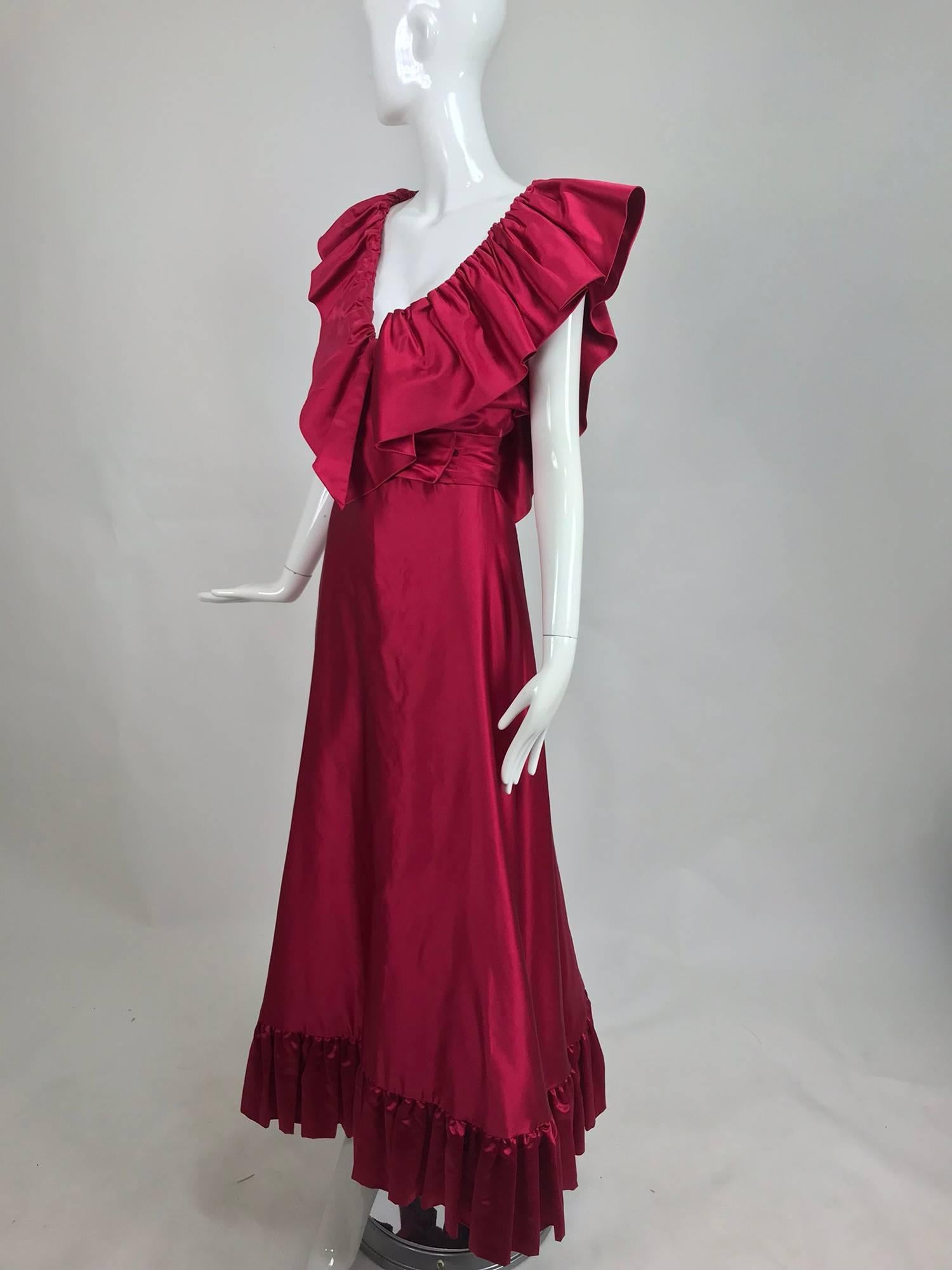 Vintage Stavropoulos plunge bodice garnet slipper satin evening gown from the 1970s. This romantic gown is made from the most incredible silk fabric, in a rich lustrous colour. The deep ruffled bodice plunges at the front and back, the ruffles sit