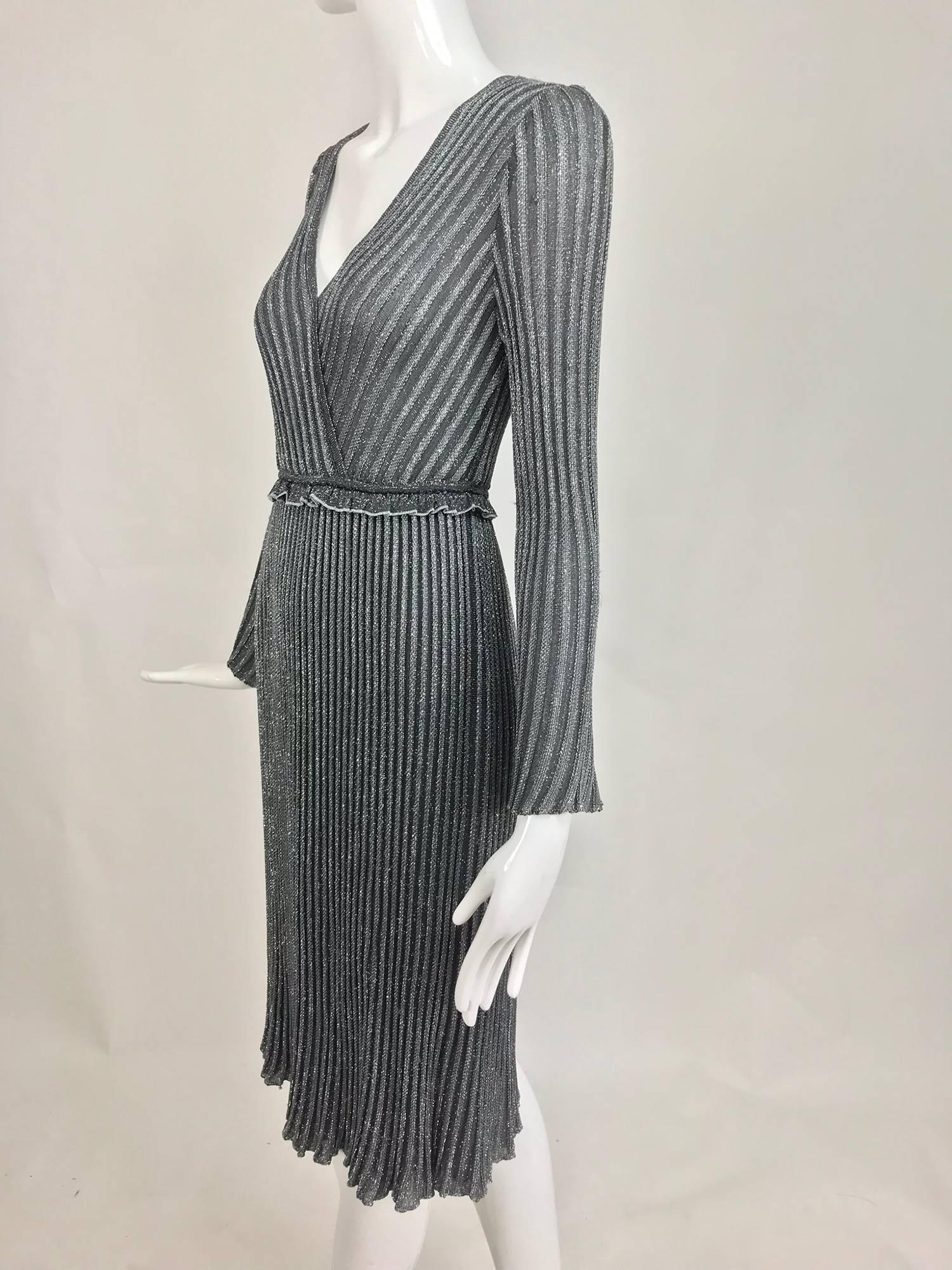 Silver metallic knit dress from the 1990s...Pull on dress has a V plunge neckline, long bell sleeves, ruffle trimmed cased elastic waist, the skirt skims the hip and flares at the hem...Fits a size small...

In excellent wearable condition... All
