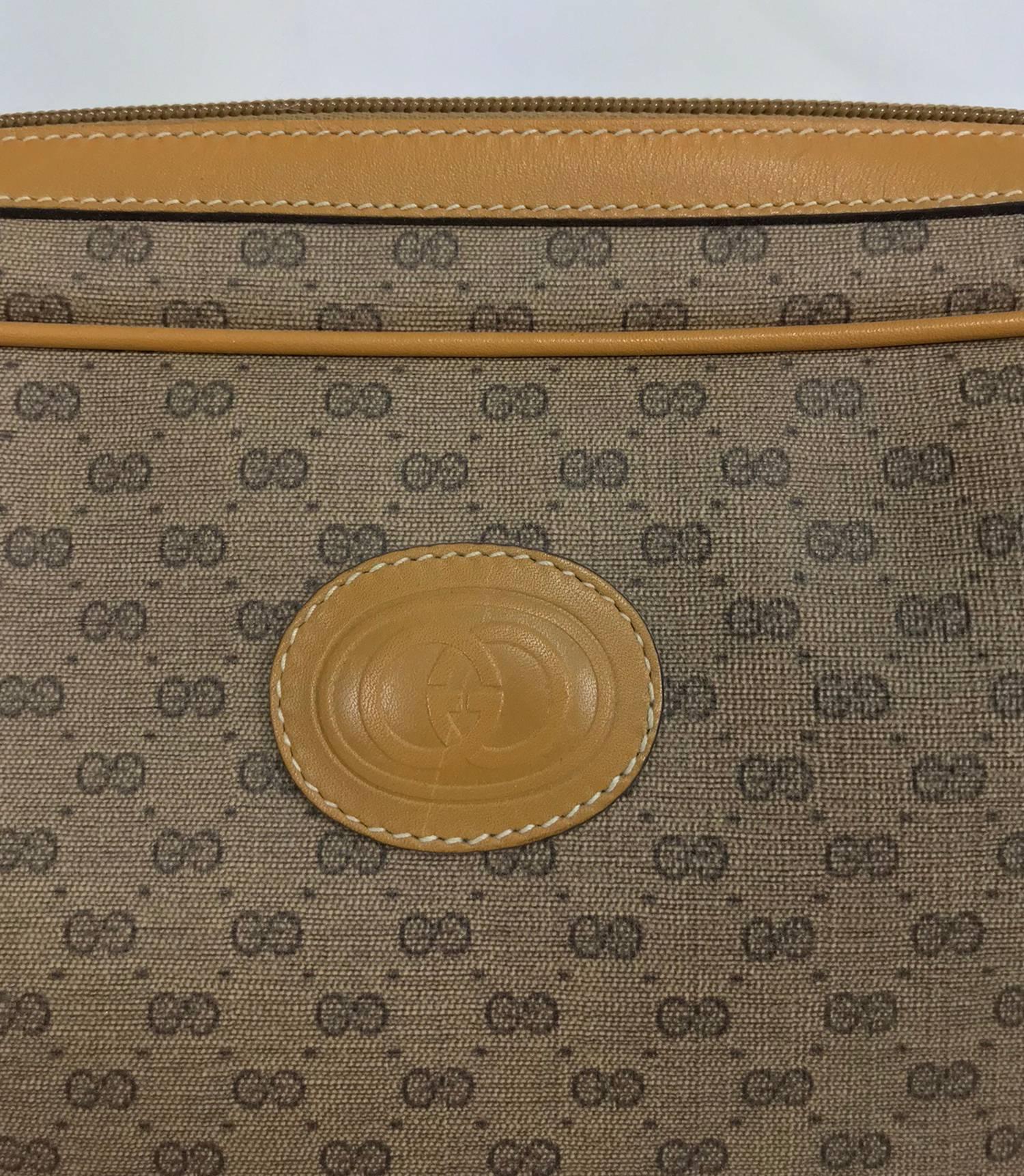 Vintage Gucci logo coated canvas and leather clutch 1980...Tan with dark brown Gucci logo print. This bag closes at the top with a zipper and Gucci leather tab. Open compartment inside, fully lined inside, lining has a couple of scratches but