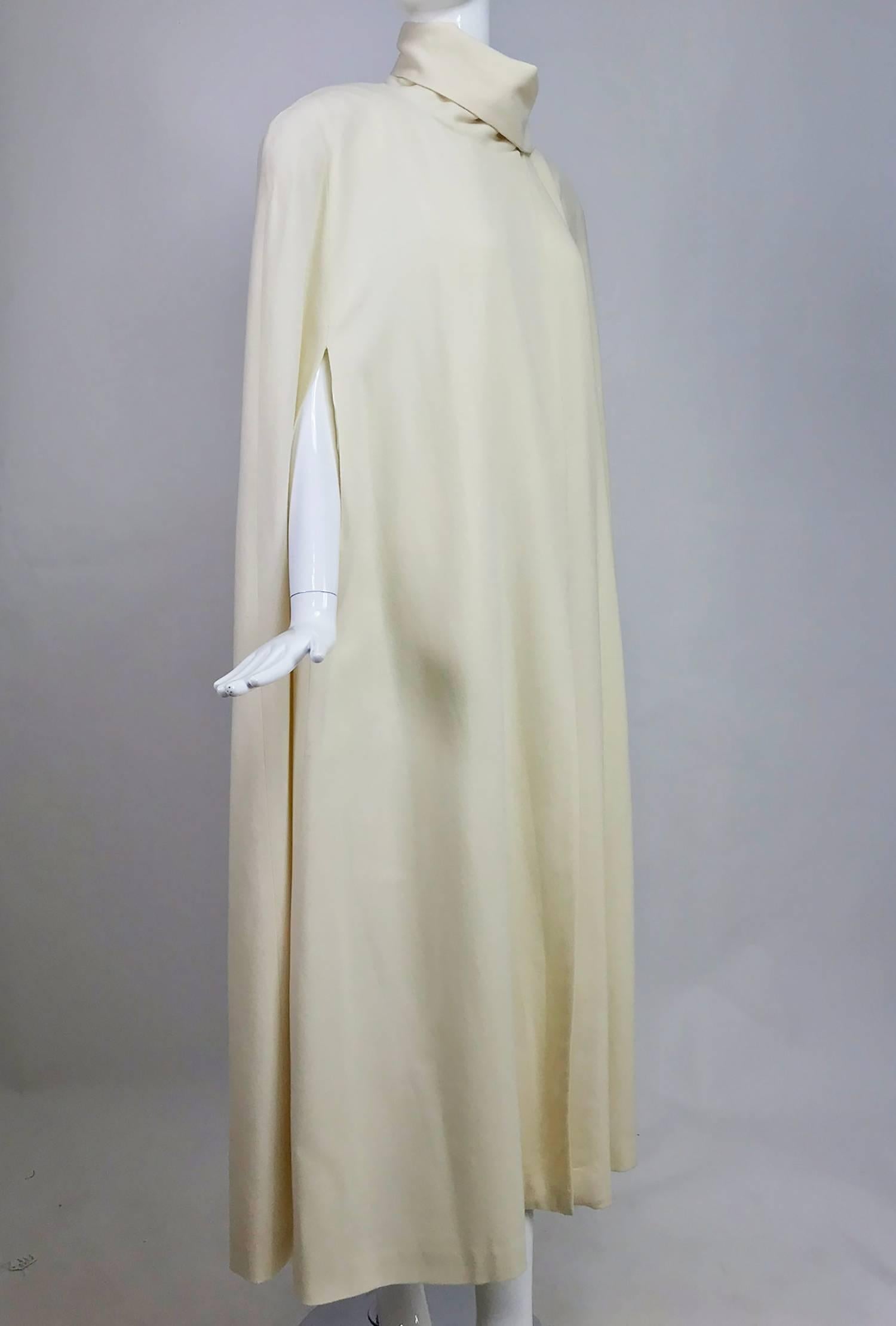 Winter white full length wool cape from the 1980s...Perfect for evening or daytime...Long A line shape cape closes with hidden snaps at the neck side front, there is an attached self scarf that can be wrapped around the neck or thrown over the
