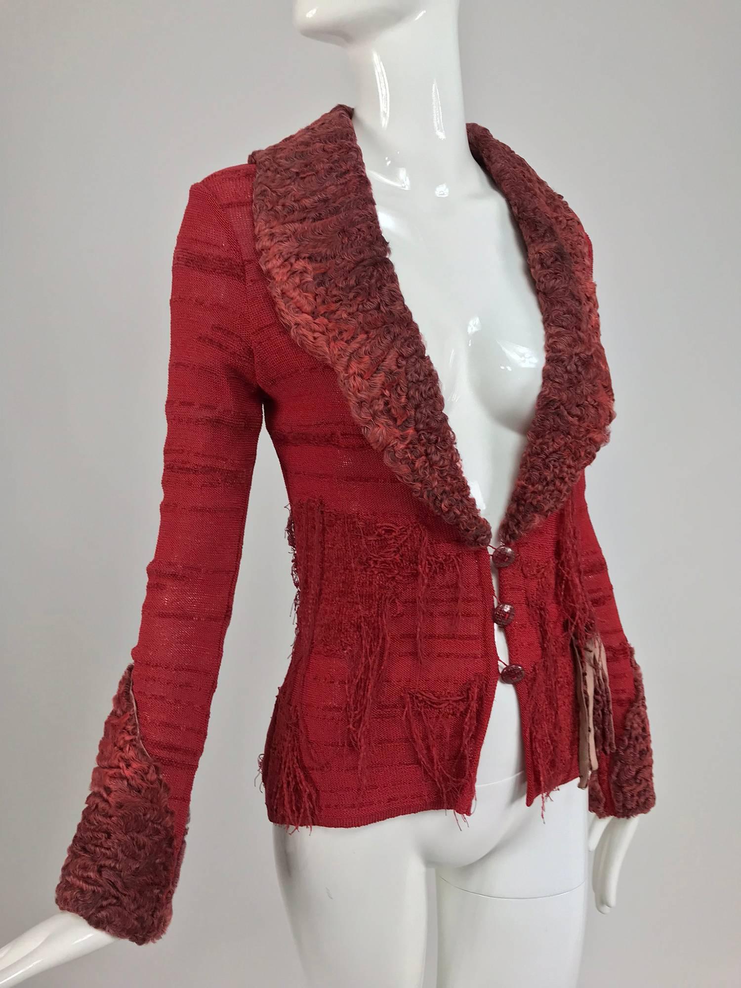 Christian LaCroix brick red sweater with dyed lamb fur trim...Cardigan sweater with dyed red lamb fur collar cuffs and appliqued fringe...This sweater is knitted in an irregular pattern using rayon and velvety synthetic yarns to create a unique