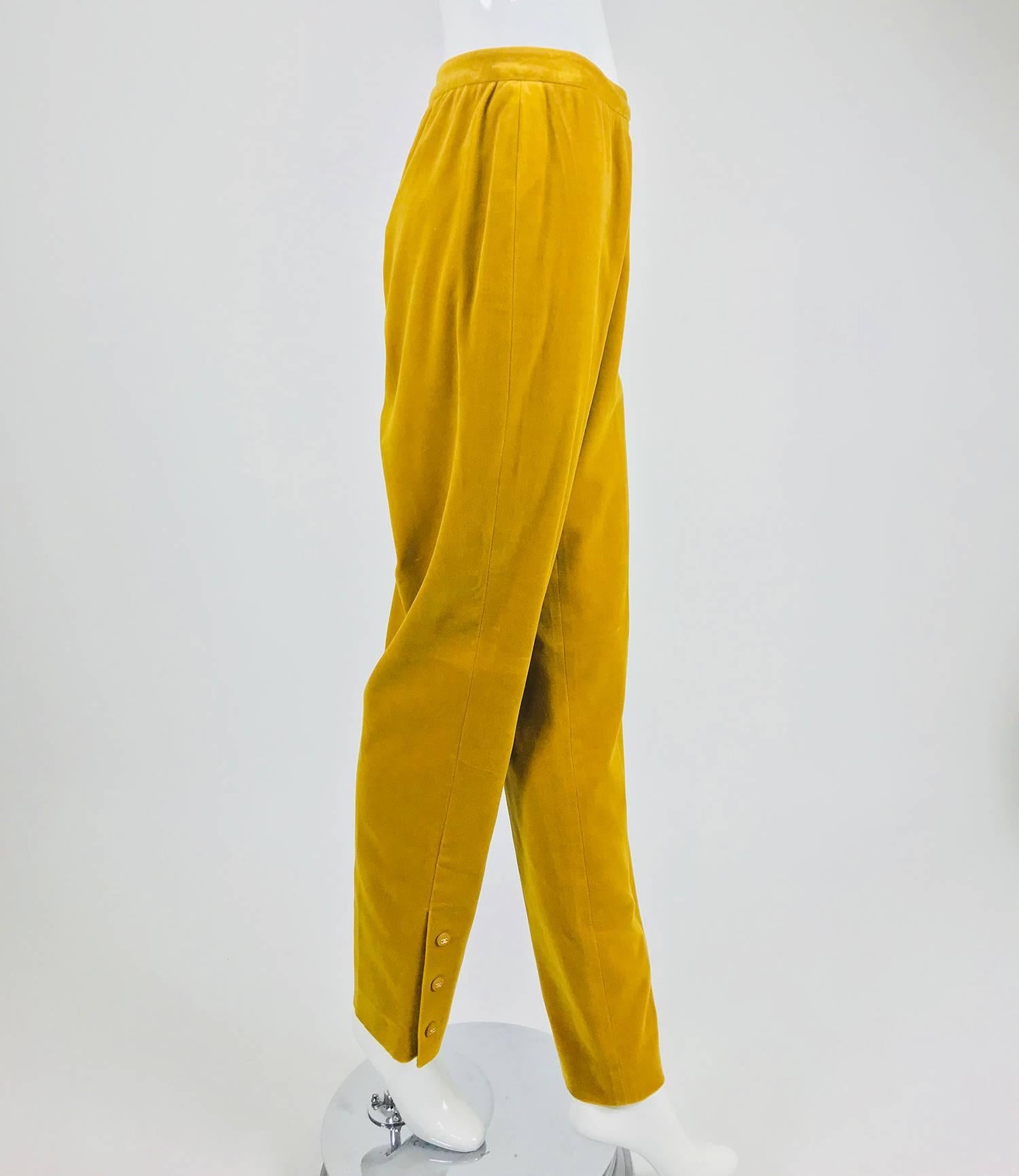 Chanel golden yellow velvet trousers with ankle buttons from the 1990s...Soft golden yellow velvet trousers sit at the natural waist with a waist band that closes at the side with button at the waist and a zipper below...Fuller at the hip and thigh