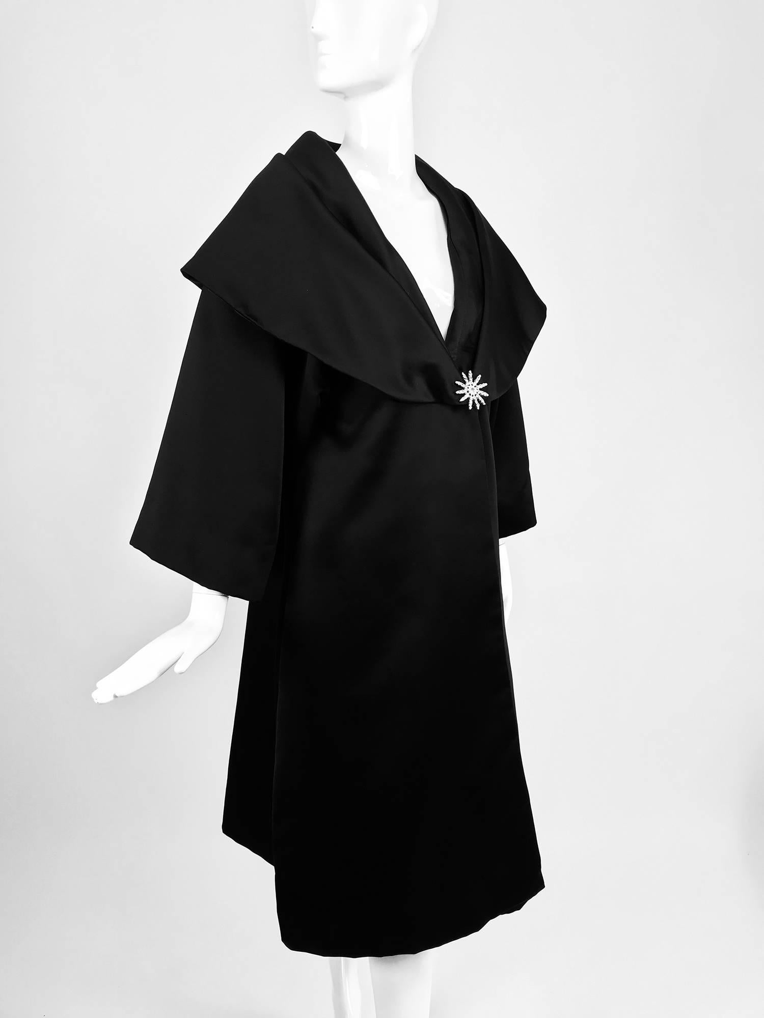 Carol Mignon Boutique Black portrait collar jewel closure evening coat from the 1980s...A beautiful coat that looks unworn...Portrait collar,crystal rhinestone jewel at the front closure...Bracelet length raglan sleeves...
In excellent wearable