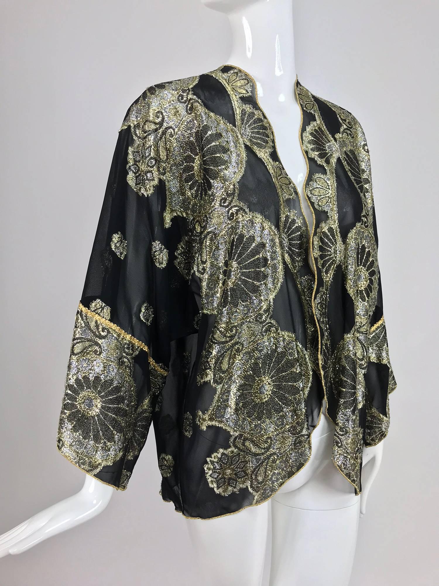 Vintage black chiffon with silver and gold metallic pattern kimono style jacket from the 1970s...Unlined, open front jacket is perfect for layering...Sheer chiffon with woven metallic designs...Fits a size small-medium
In excellent wearable