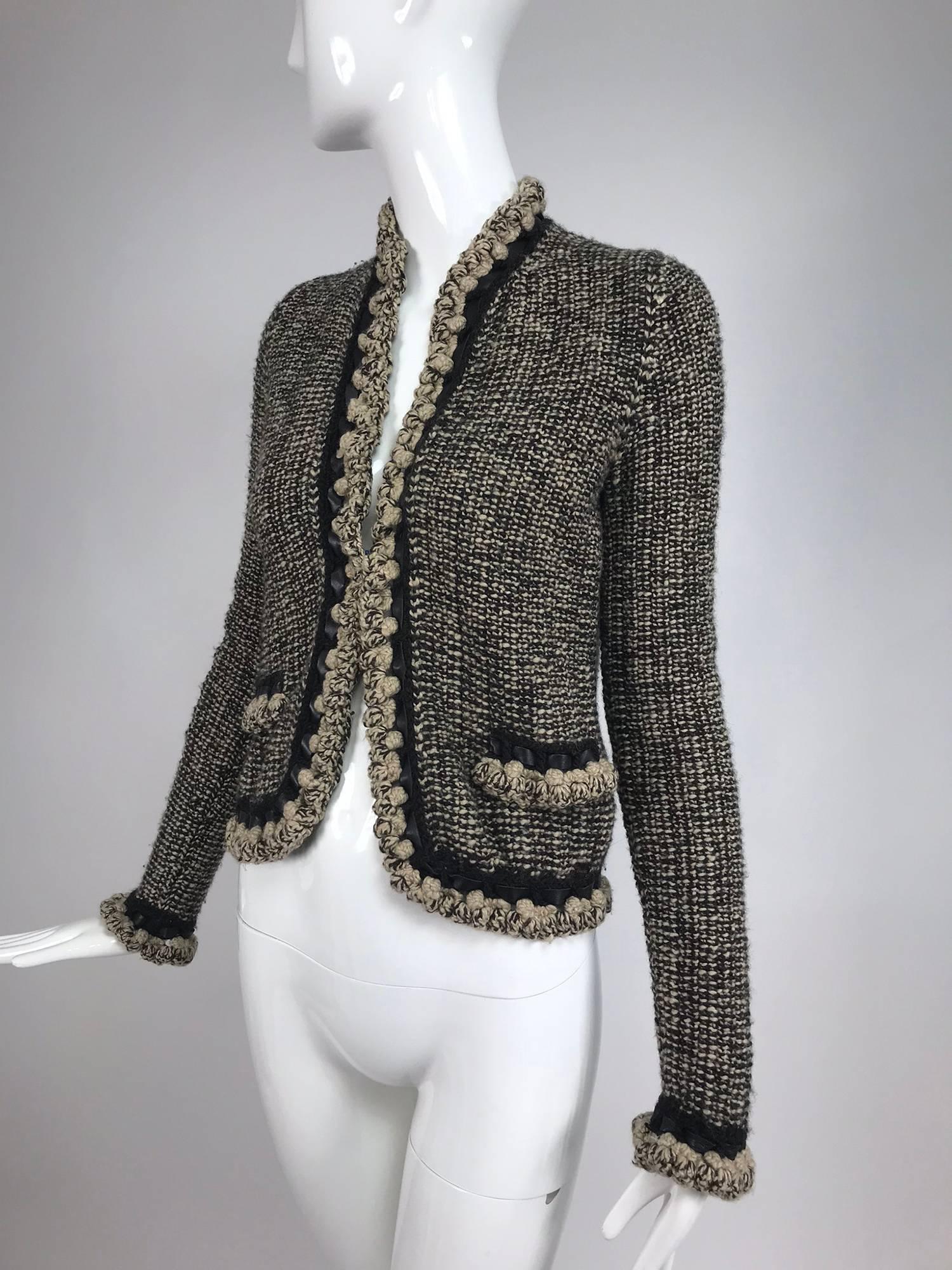 Chanel black and cream cropped leather trimmed jacket 2001A...Unlined jacket with chunky knit trim that that has leather woven in, front band pockets...This jacket has the feel of a mid weight sweater...No closures at the front...Marked size