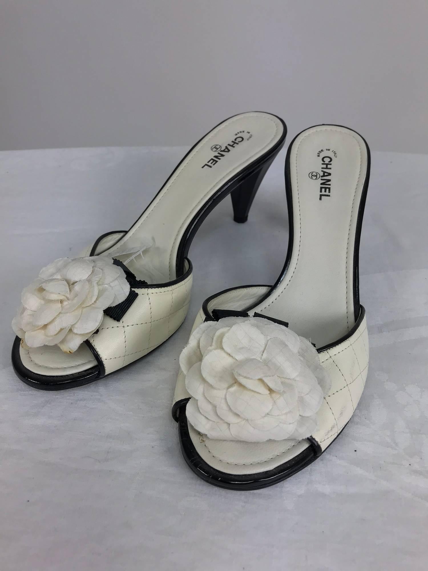 Chanel cream quilted mules with patent heels and Camellia flowers at the front 38 1/2 M...The left shoe outside near sole has some very light scuff marks, see photo, there is a bit of yellow on the right lower flower petal see photo which looks