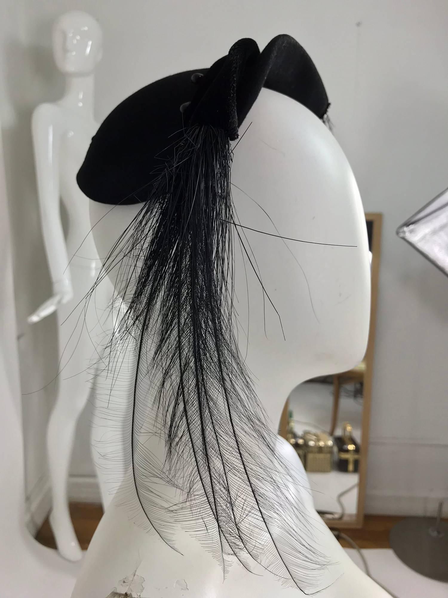 Frank Palma black bird of paradise feather cocktail hat from the 1950s. Black felt cap style hat (made to sit on the top of your head), the front of the hat is is made in two separate parts, one side of black velvet, the other of black felt, either