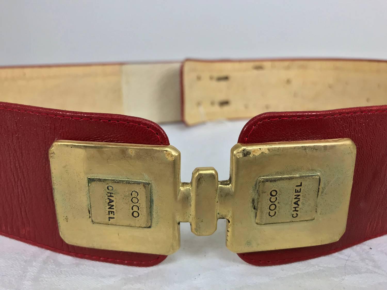 Chanel Coco gold bottles with red leather belt from the 1980s, possibly 1984, the year Coco perfume was introduced...Two gold perfume bottles of gold metal share a top to form the 