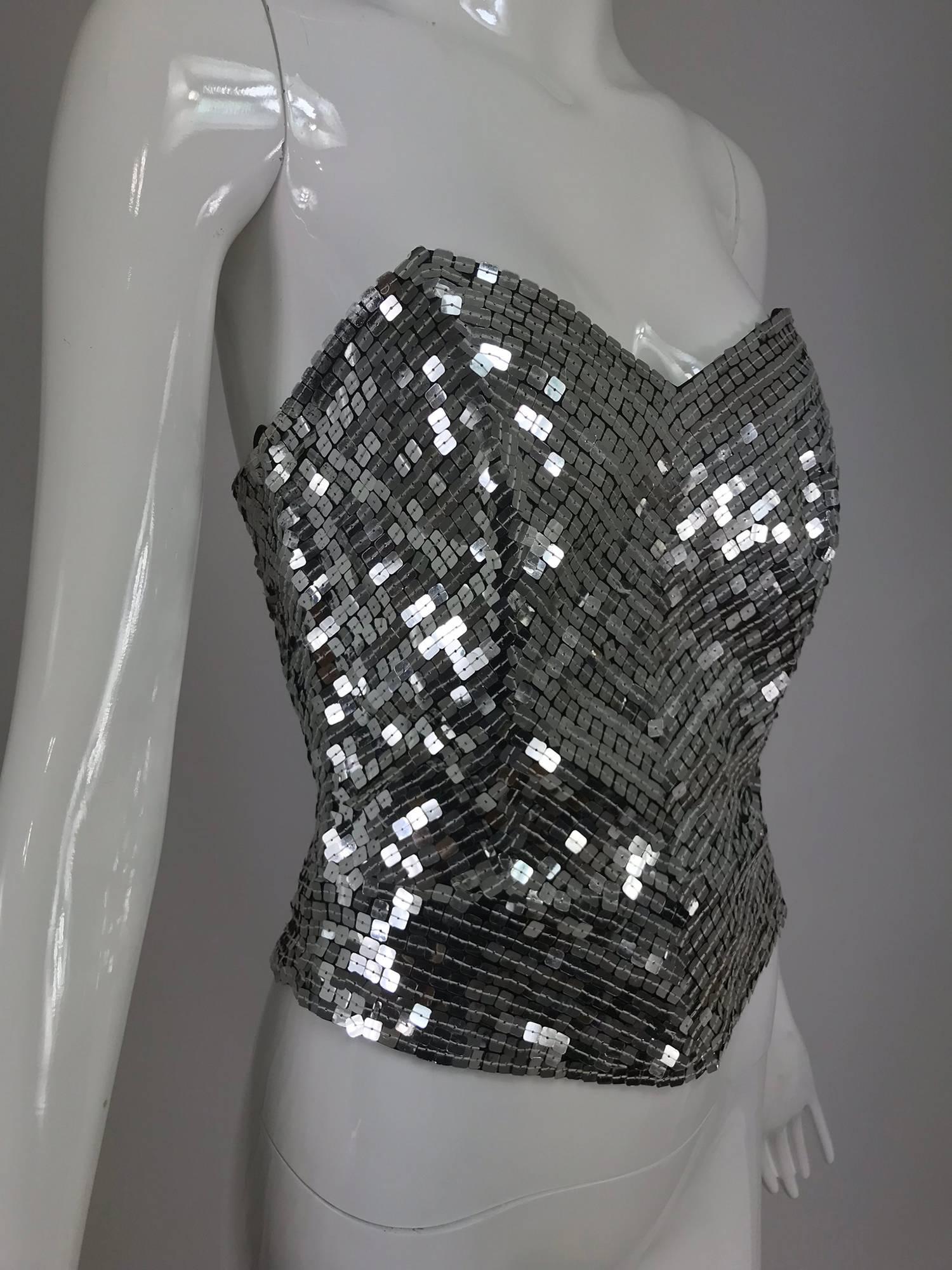 Oleg Cassini silver sequin bustier from the 1980s...Boned bustier with square silver sequins, closes at the back with a zipper...Peplum hem...Unlined...Fits a size 4-6
.
In excellent wearable condition... All our clothing is dry cleaned and