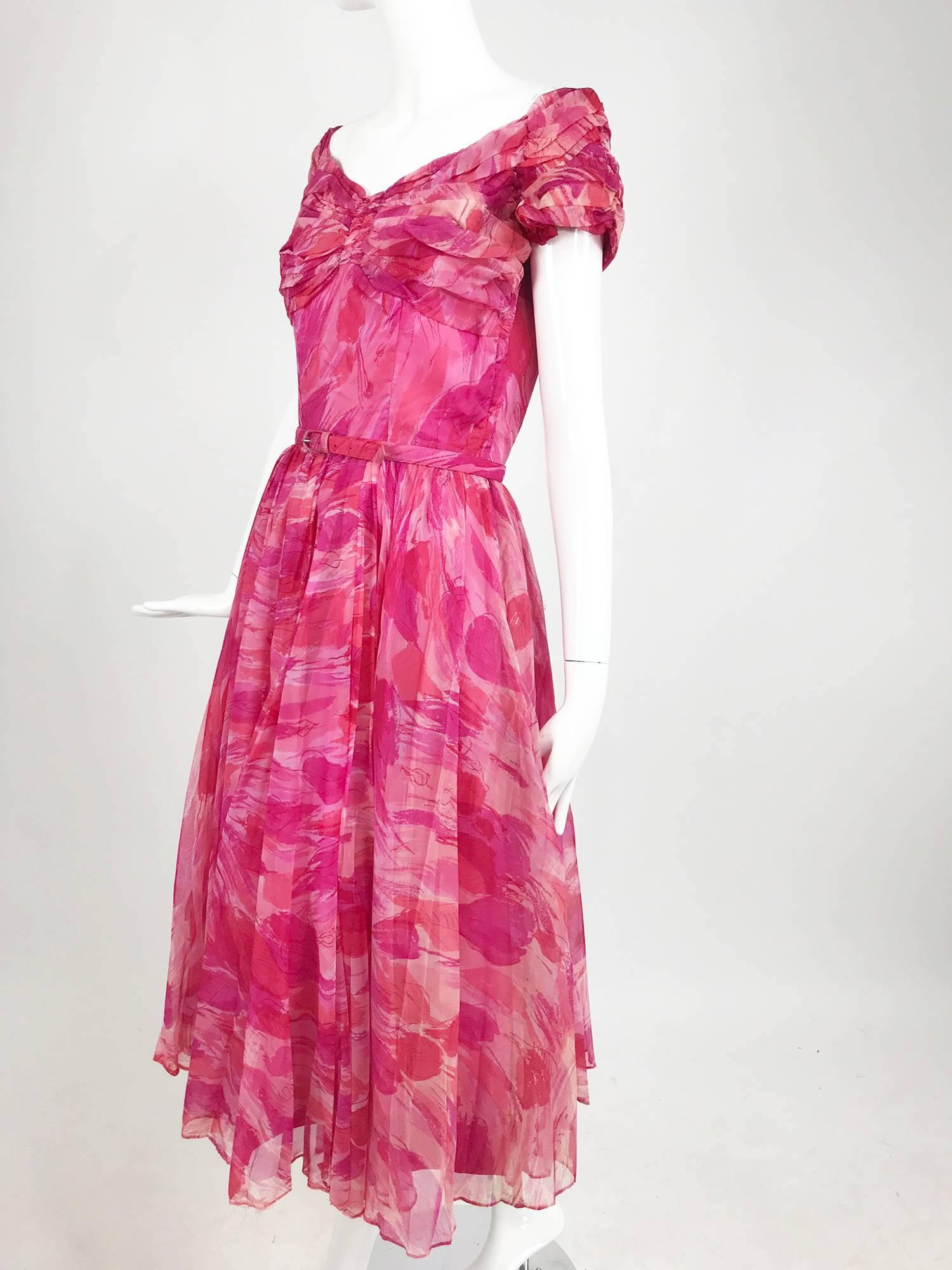 Hot pink modernist floral print off the shoulder, early 1960s organza dress. The bodice features raglan sleeves that sit at the shoulder edge, center bust front is gathered the bust is loosely pleated at each side, the bodice is fitted below to the