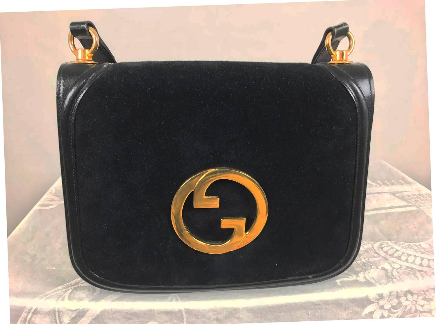 Gucci black suede and leather Blondie shoulder bag from the 1970s with gold hardware. Iconic bag of deep black suede trimmed in black leather with a black leather adjustable shoulder strap. The flap front bag features a large gold metal Gucci logo