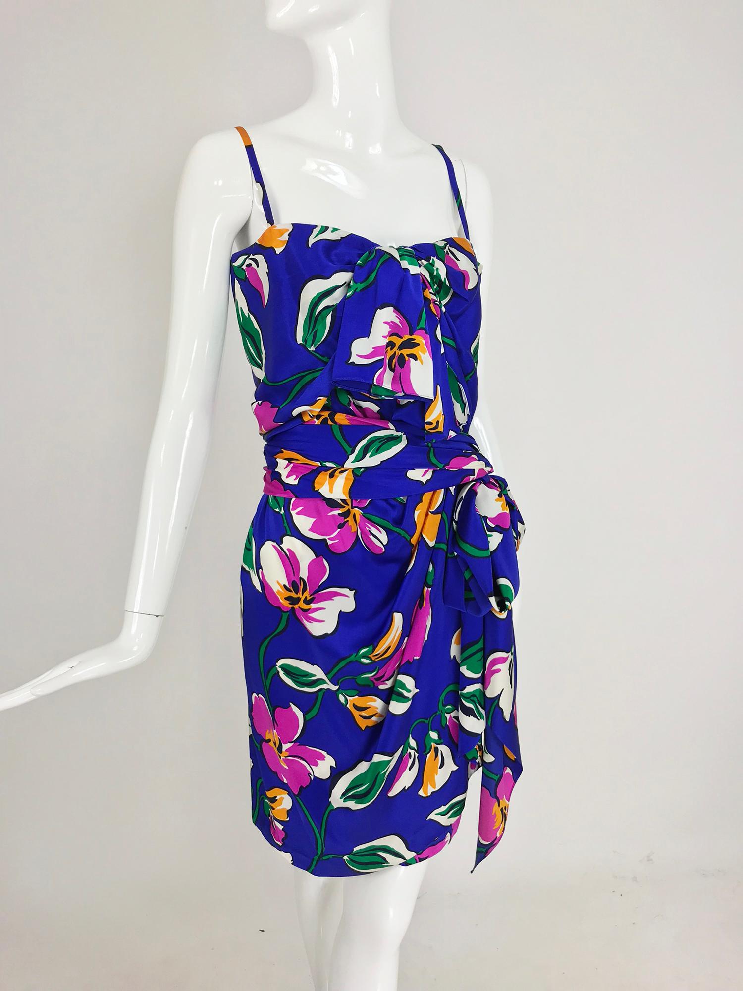 Givenchy Nouvelle Boutique tropical silk satin sarong dress from the 1980s. Silk satin tropical print dress with a deep purple blue ground. The dress has spaghetti straps, the bodice closes at the front with a hidden zipper, there is a tie at the