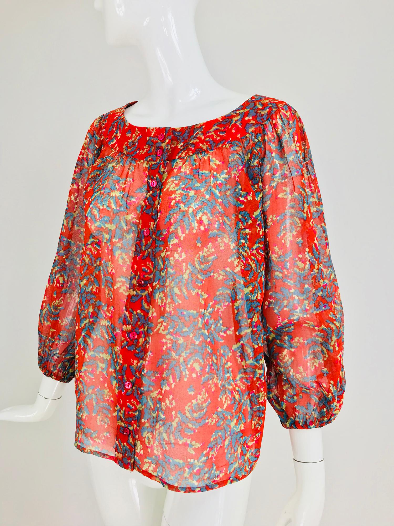 Yves Saint Laurent sheer floral cotton blouse from the 1970s. Peasant style blouse of sheer cotton voile, the banded neckline has light gathering with a full body, 3/4 length full raglan sleeves with cased elastic cuffs. The blouse closes at the