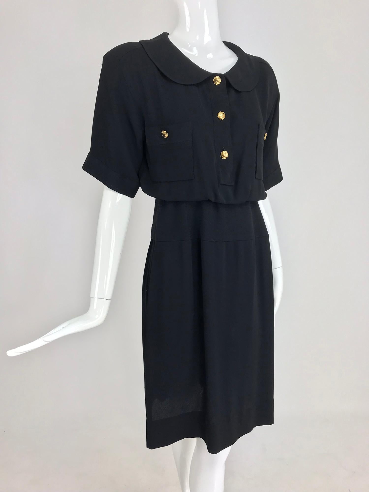 Chanel vintage black crepe shirtwaist day dress. Classic shirtwaist style dress with cuffed, short sleeves, round collar at the neckline, button front bust patch pockets and button front with gold Chanel 4 leaf clover buttons, the dress has a cased