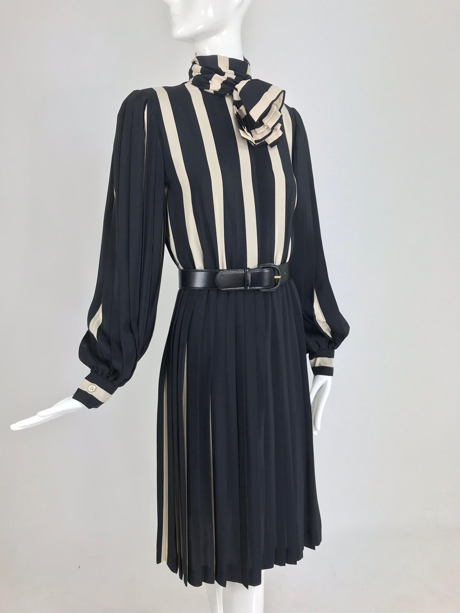 Bill Blass pleated silk black and tan stripe dress from the 1970s. Shirtwaist style dress features long full pleated sleeves with banded cuffs that close with buttons. The dress closes at the front with hidden buttons, there is an attached neck wrap