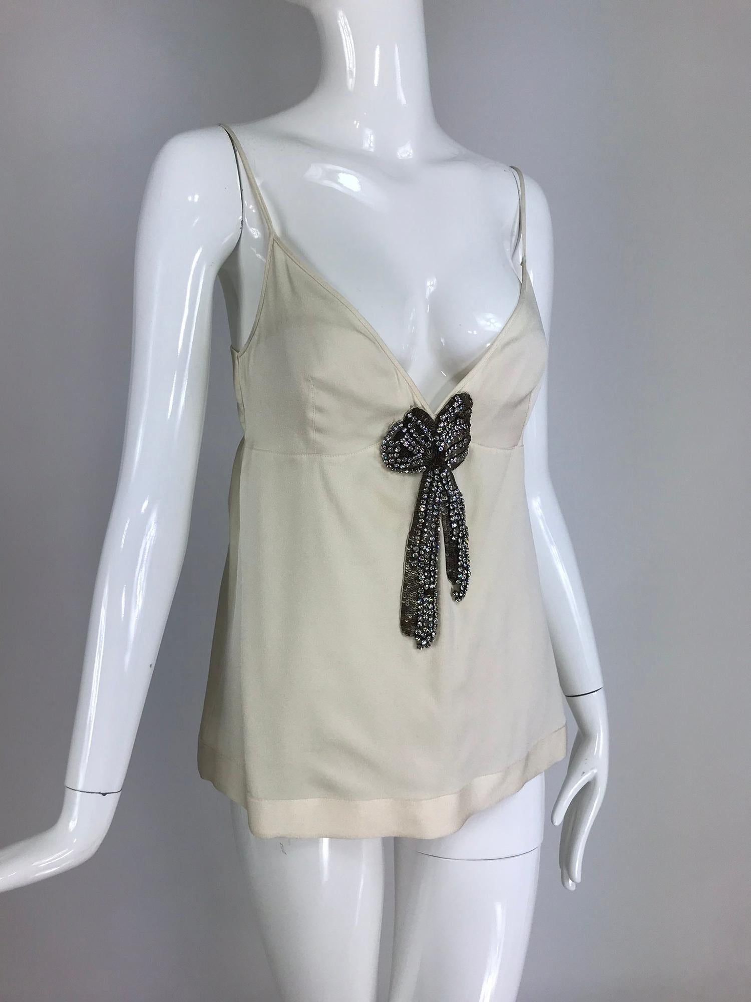 Alexander McQueen Ivory Silk with Rhinestone Bow Camisole Top. Silk top in ivory with a  plunge V neckline, seamed darts under bust and horizontal seam under bust. A large applique bow of prong set rhinestones and gold sequins is the centerpiece of