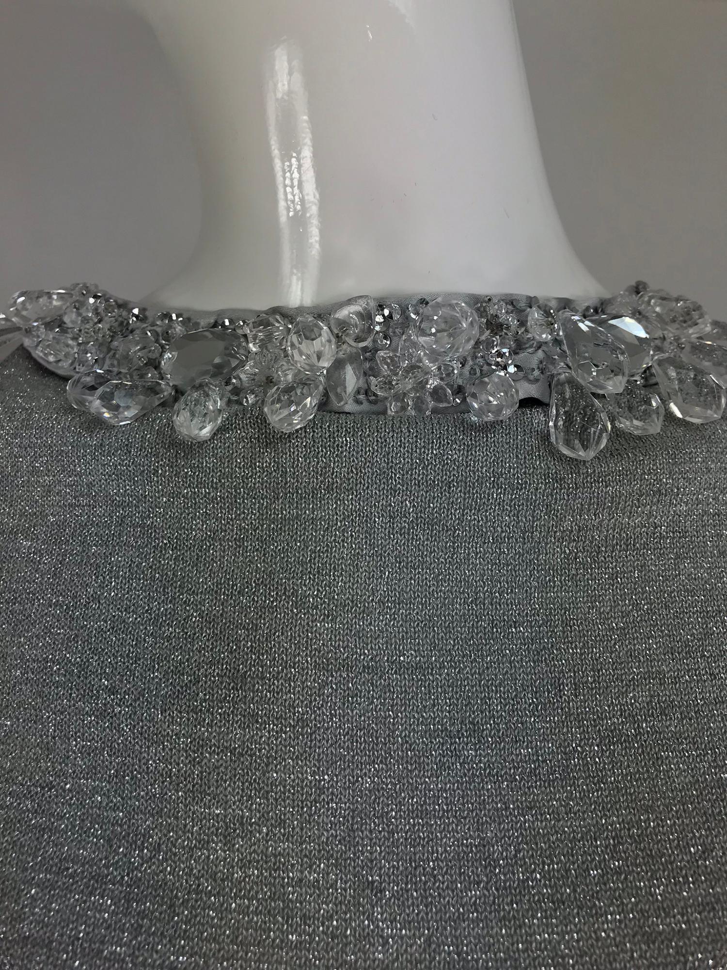 Prada silver metallic grey rhinestone collar cardigan sweater. Button at the front or back, unlined cardigan sweater has a heavily crystal, mirror and sequin neckline. Closes with silver buttons. Fits a size small. The label has been removed.

In