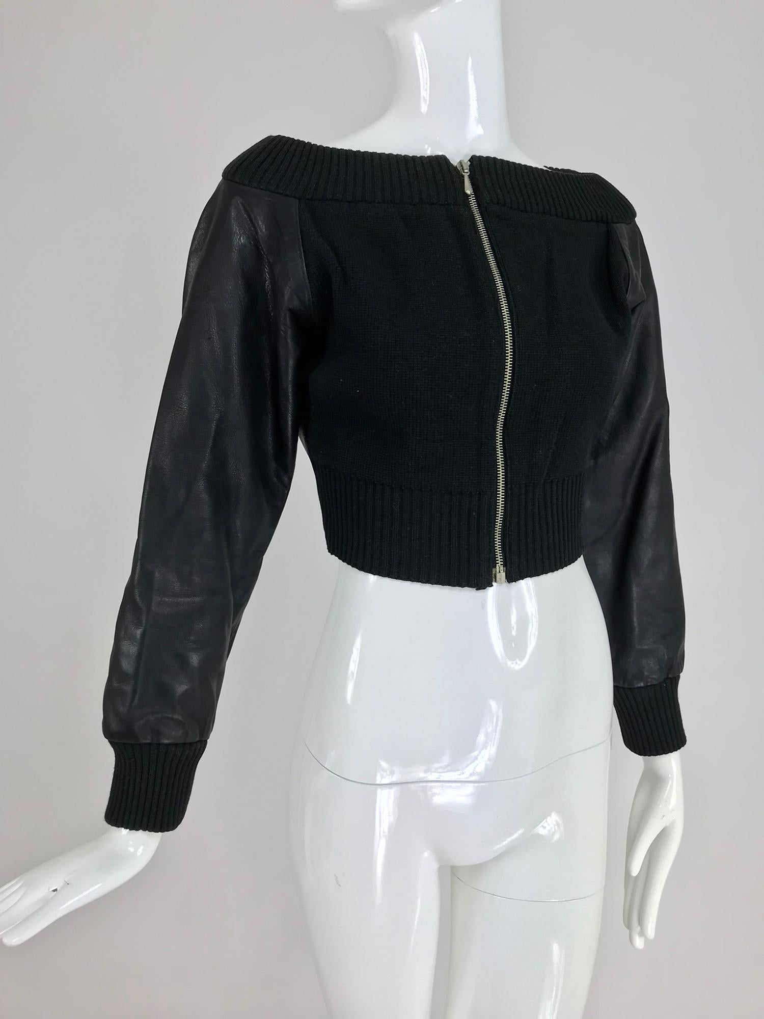 Jean Paul Gaultier black leather and black Knit Off the Shoulder Jacket from the 1990s. The cropped, fitted long raglan sleeve jacket has black leather sleeves and back with knit front panels, a rib knit shoulder band and rib knit cuffs, it closes