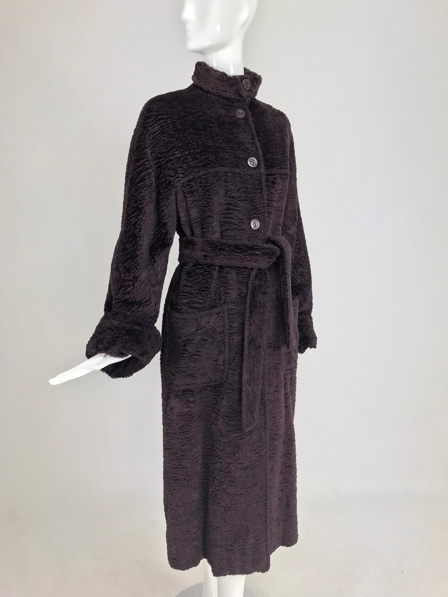 Fendi Aubergine Faux Karakul Belted Coat from the 1990s. This beautiful coat closes at the front with Fendi logo buttons, the neck closes as a turtle neck, turned over to protect your neck from the wind. The long sleeve coat has deep turn back