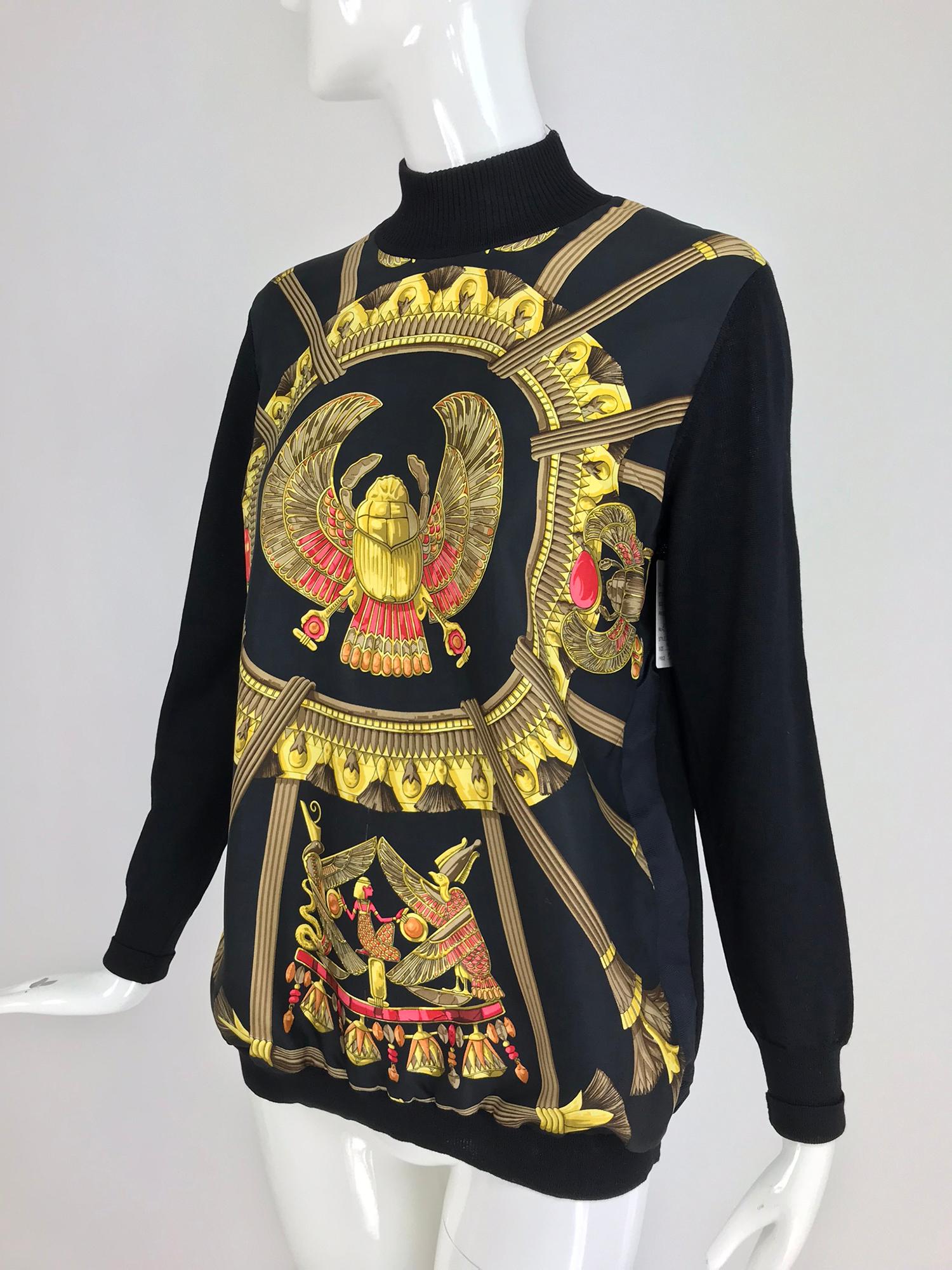Hermes Scarab Scarabees et Pectoraux silk twill scarf sweater from the 1970s designed by Caty Latham. Fine black wool knit sweater, pull on style with a mock turtleneck that has a side zipper opening. The front of the sweater is made from Hermes
