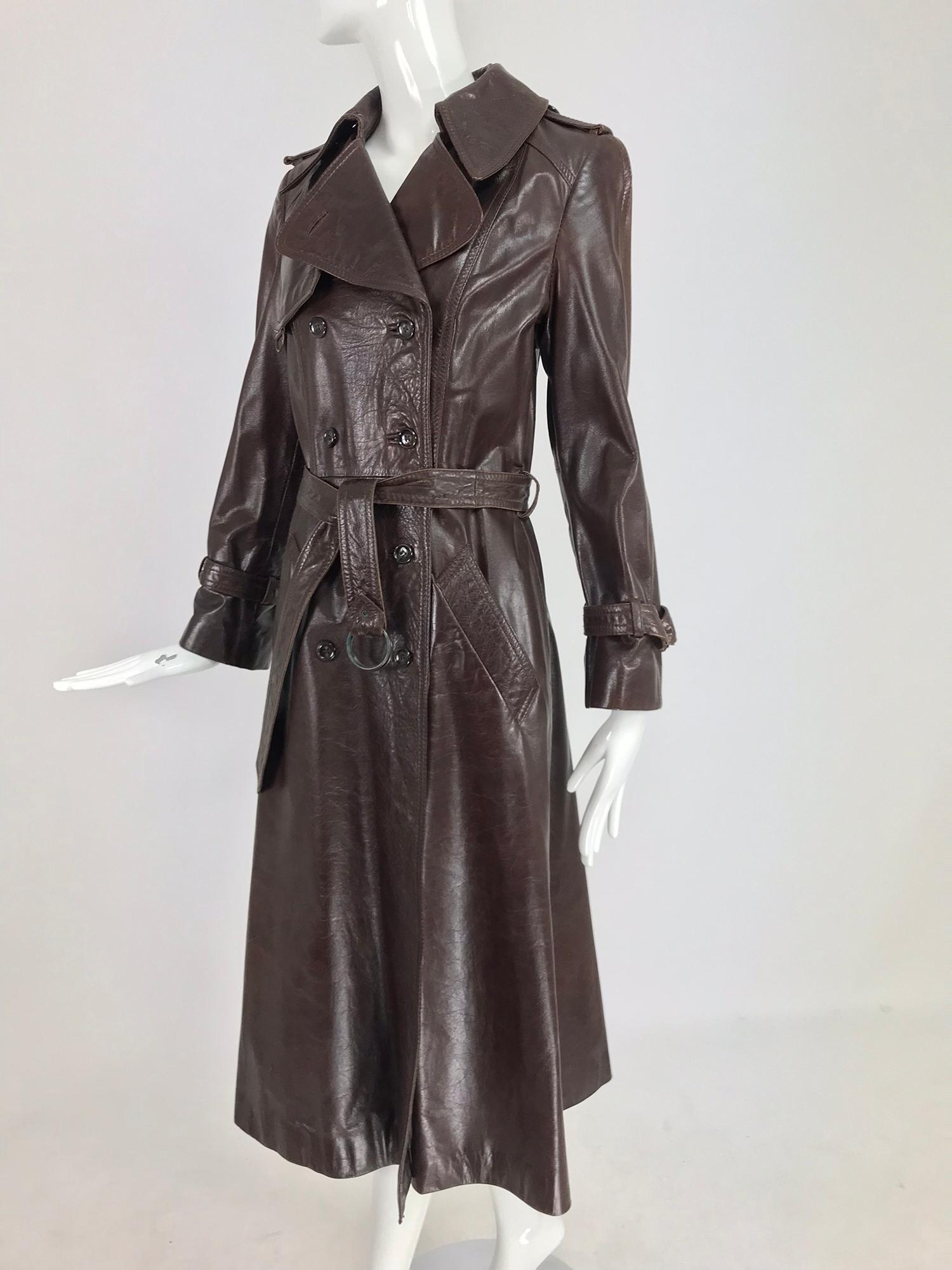 Anne Klein chocolate brown leather trench coat a 1970s classic. Beautiful chocolate brown leather trench with all the details and 70s flair. The leather on this coat has taken on a beautiful patina. Fitted coat has a seamed waist and A line skirt.