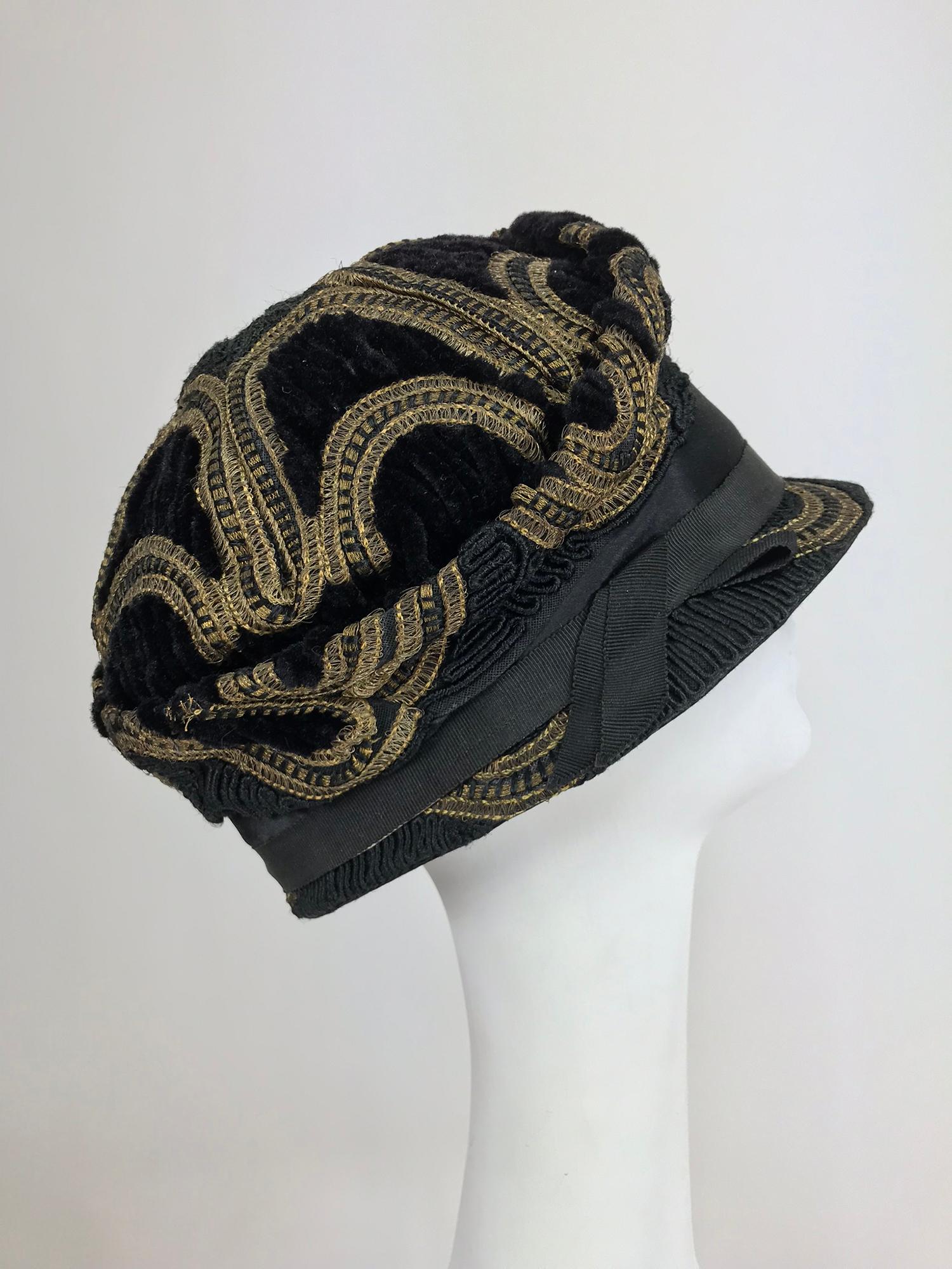 1920er Jahre Flapper Metallic Passepartout Cloche Hut. Dieser wunderschöne Hut ist aus schwarzem Chenille-Samt, schwarzem Satin und goldener Metallic-Borte handgefertigt. Der Hut hat eine geformte Krone und eine schmale Krempe. Innen mit