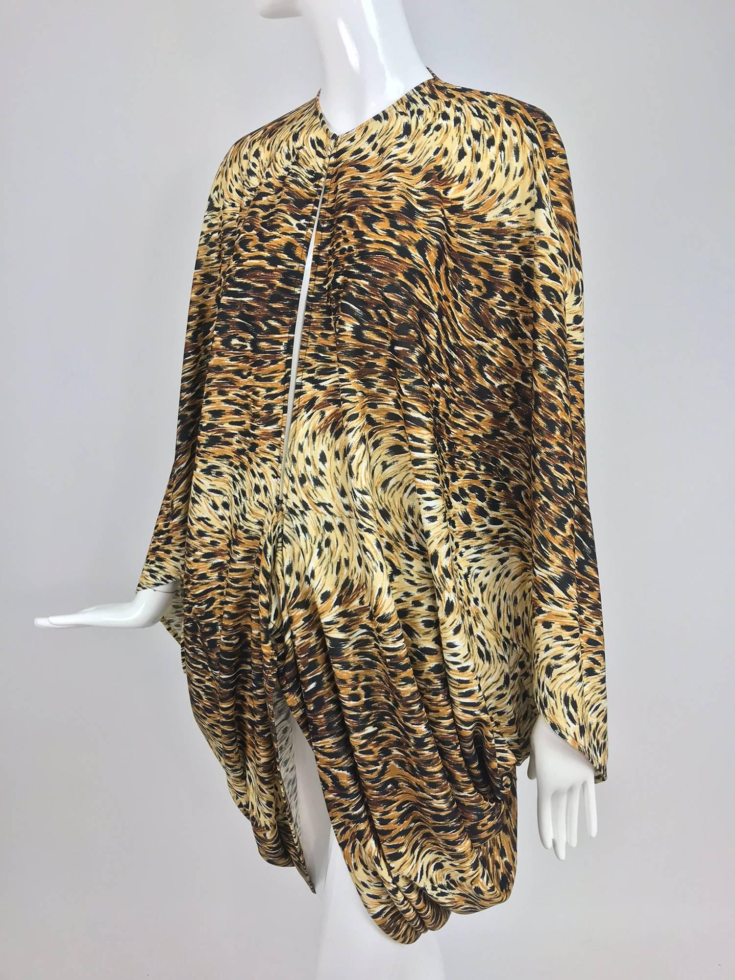 Norma Kamali OMO leopard print cocoon jacket from the 1980s. Unlined nylon/spandex jersey cocoon jacket closes at the front with a hook and eye. Draped shape with arm openings, longer at the back. Fits a size small or medium.
In excellent wearable