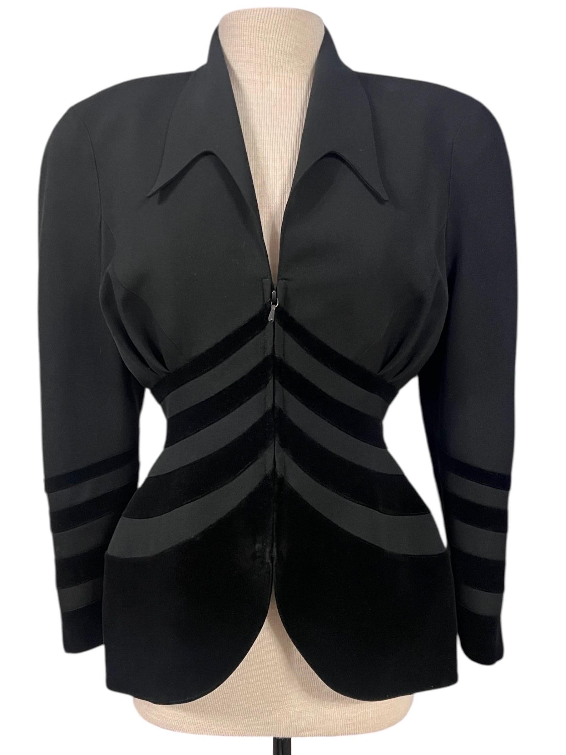 Diese umwerfende schwarze Jacke von Thierry Mugler aus den 1990er-Jahren kombiniert meisterhaft eine scharfe Schnittführung mit der klassischen skulpturalen Silhouette von Mugler. Sie ist aus einem strukturierten Stoff gefertigt und mit einem