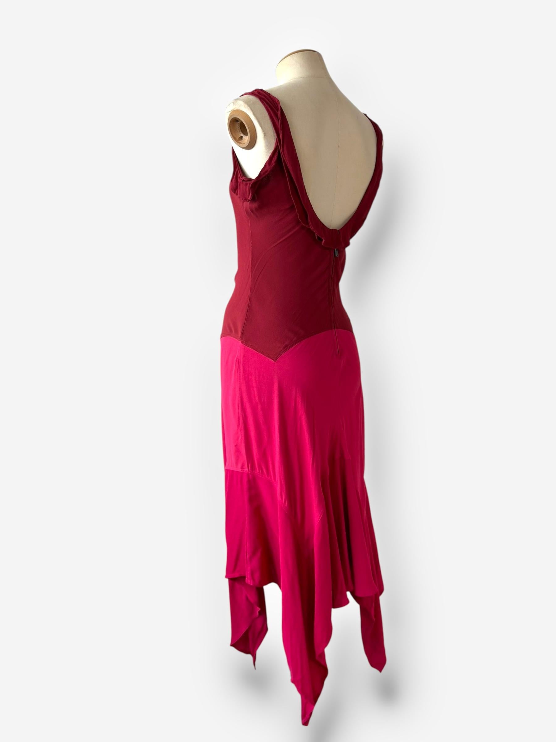 Issue des dernières années sensuelles de Tom Ford chez Yves Saint Laurent River Gauche, cette robe en crêpe de soie framboise de la saison S/S 2004 illustre sa maîtrise des silhouettes fluides et de la retenue provocante. Le design présente un