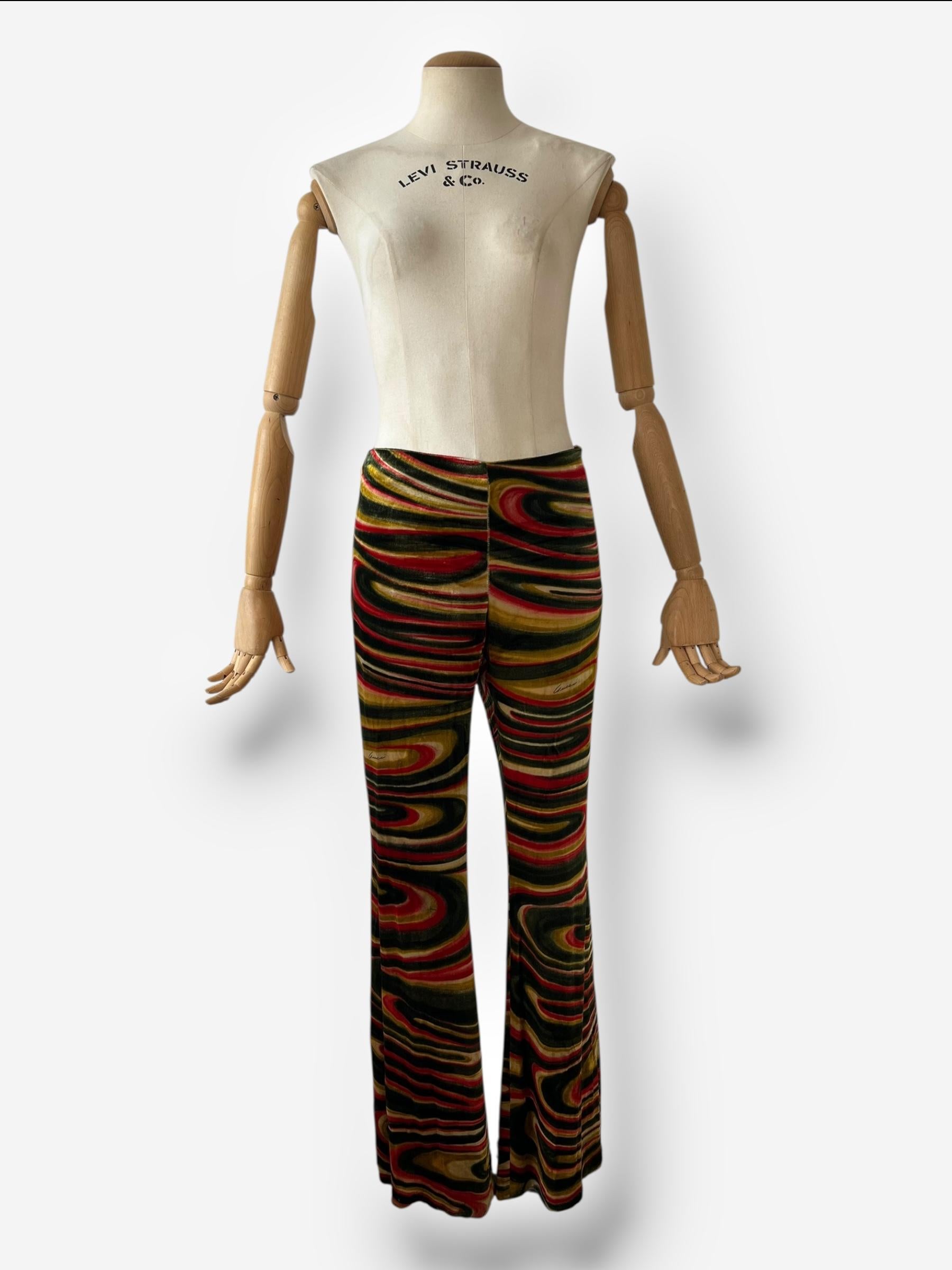 Pièce emblématique de l'époque légendaire de Tom Ford chez Gucci, ce pantalon évasé à taille moyenne de la collection Automne/Hiver 1999 est un véritable bijou pour les collectionneurs. Confectionné en Italie dans un luxueux velours à imprimé