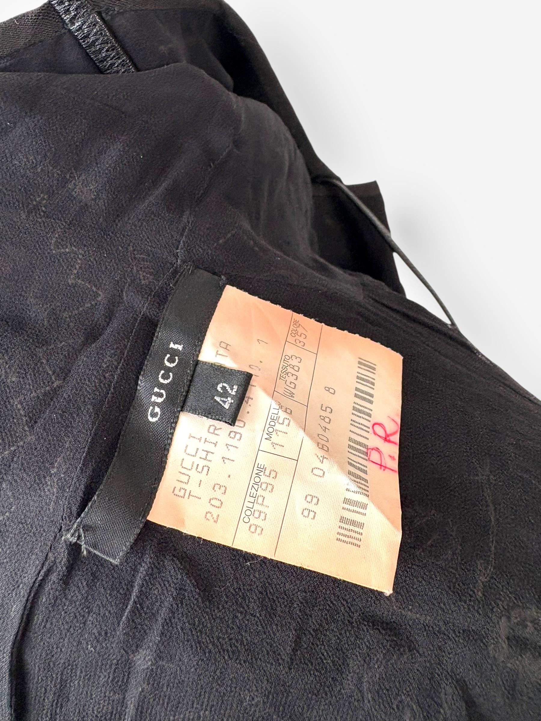  Primavera/Verano 1999u2028De una de las colecciones más icónicas de Gucci bajo la dirección de Tom Ford, este top de pasarela sin espalda de la Primavera/Verano de 1999 presenta un intrincado bordado de espejo sobre algodón negro. El alto escote en