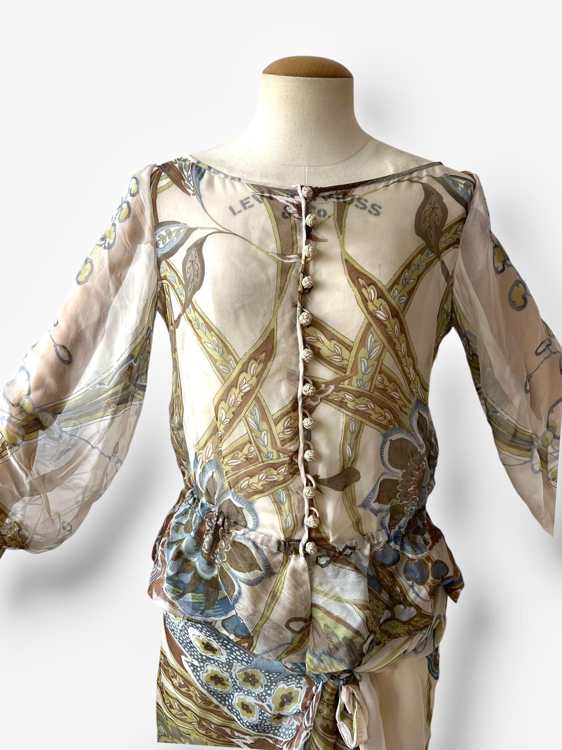 Un ensemble romantique et éthéré en soie de Valentino, datant du début des années 2000, probablement autour de 2003. L'ensemble comprend une blouse imprimée transparente avec de longues manches ajustables, des poignets noués par des rubans et une