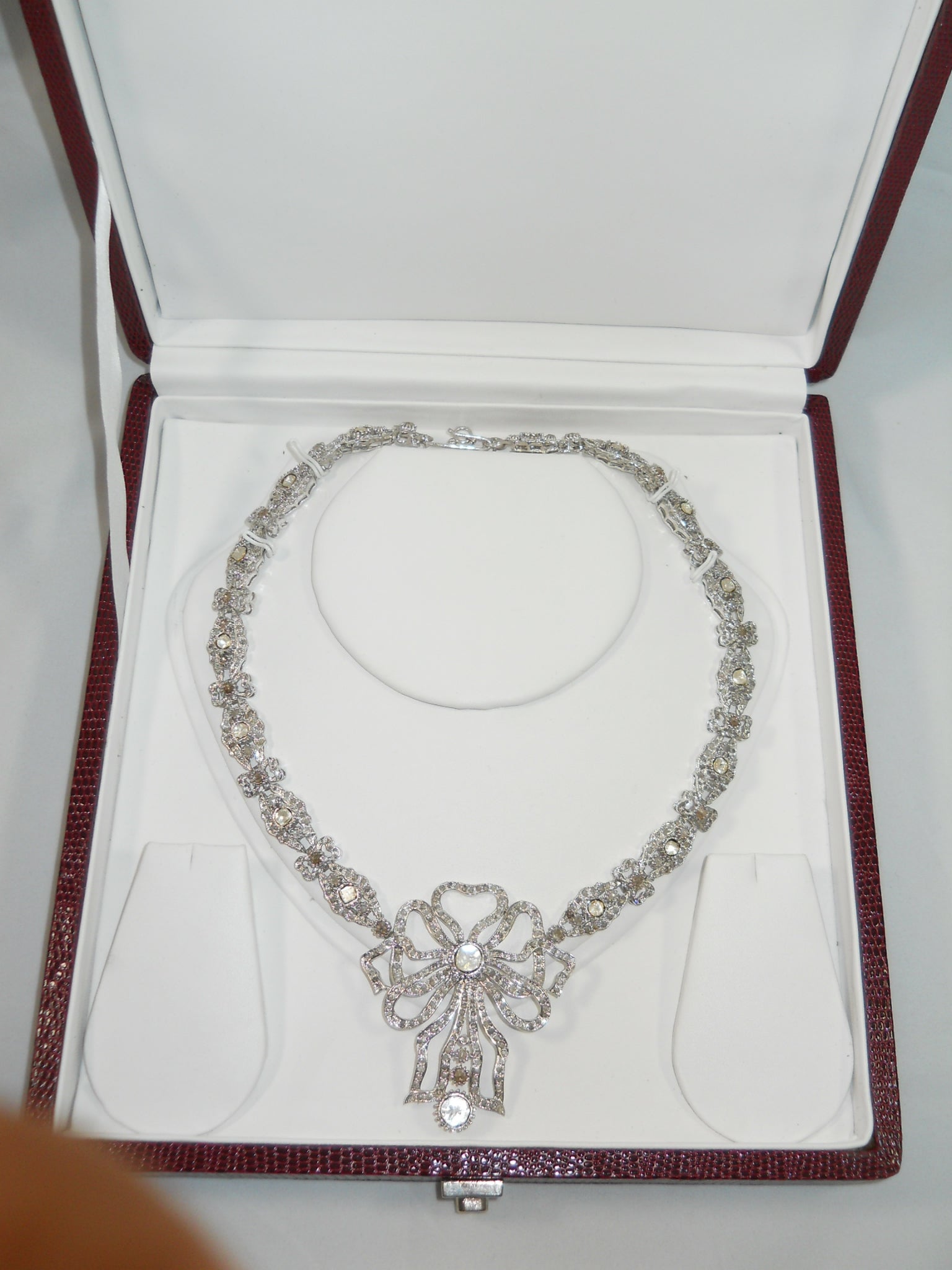 This gorgeous ribbon bow uncut rose cut diamond silver necklace is unique in itself. It has been created by the fine artisans using Natural real Uncut Diamond and real rose cut diamonds. The diamonds have been set in such a way that their luster