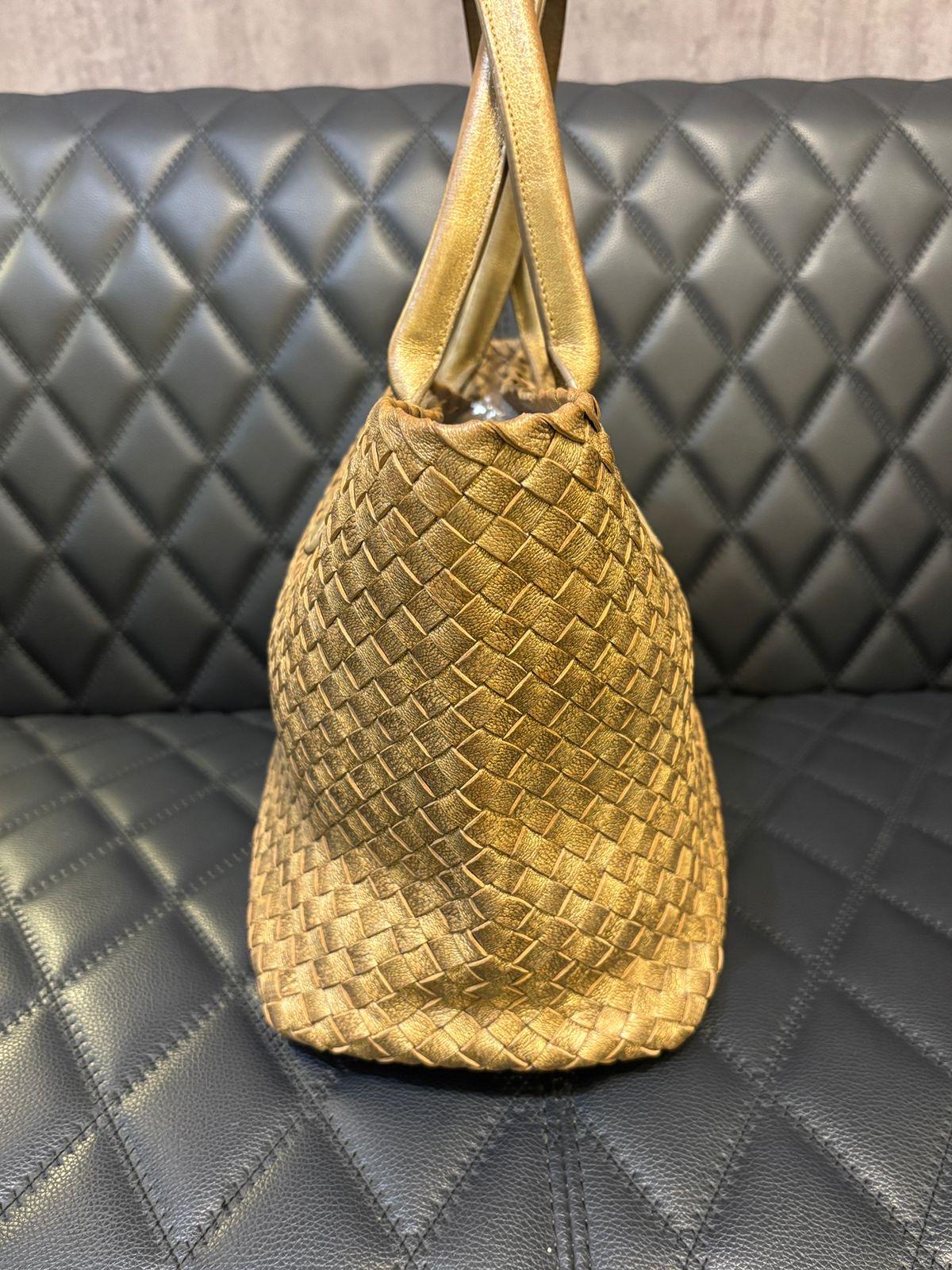 Bottega veneta Leder gewebt tote in Gold Bronze Farbe. Der Artikel ist in einem guten Zustand, mit Abrieb an den Ecken und Flecken auf dem Leder und dem Lederfutter. Wird mit Lederetui geliefert. Oxidation an der Hardware. Limitierte Auflage. Wird
