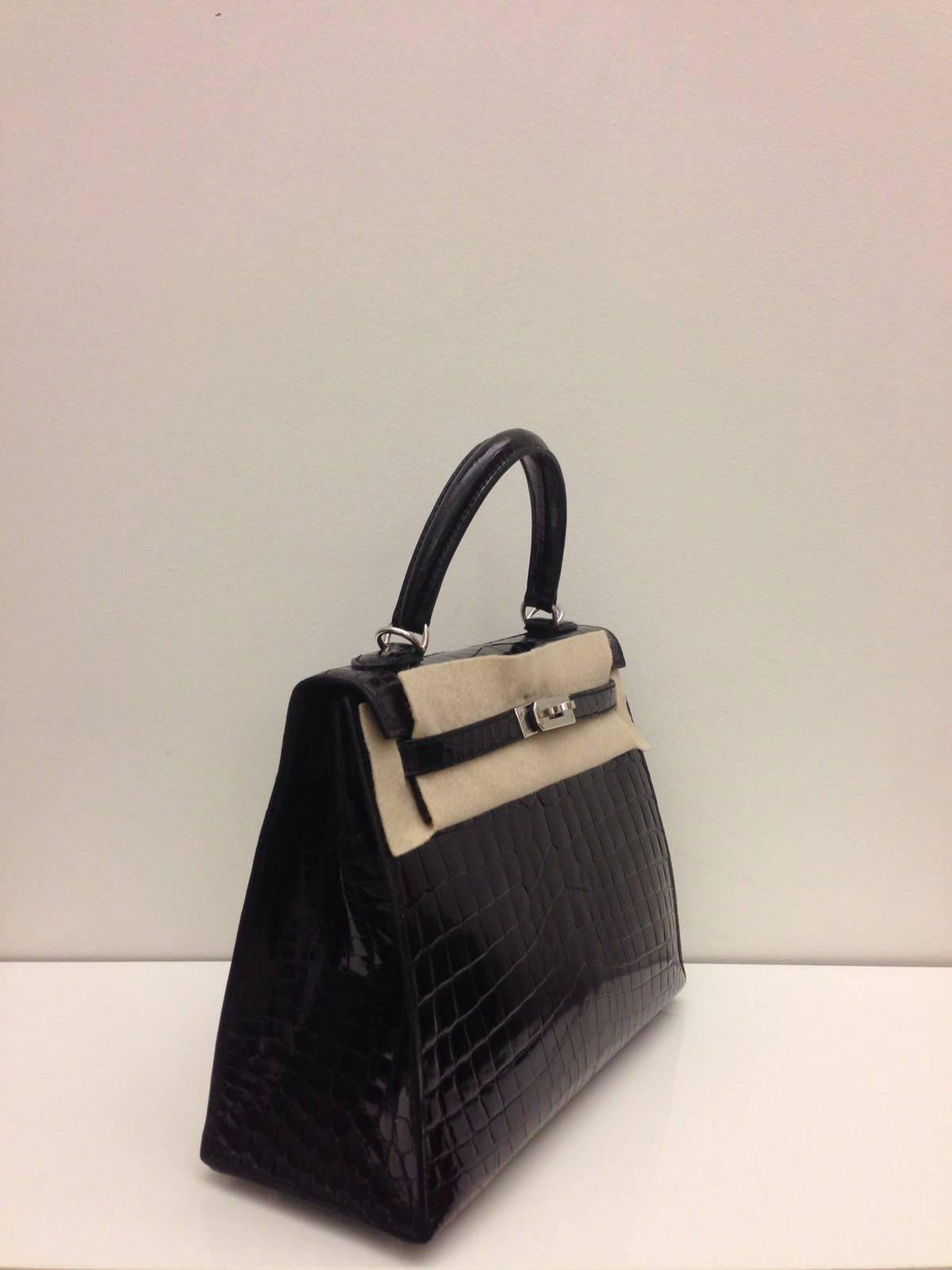 Hermes 
Kelly size 25
Shiny Crocodile 
Colour Black (Noir)
Silver Hardware
store fresh, comes with receipt and full set (dust bag, box...) 
Hydeparkfashion specializes in sourcing and delivering authentic luxury handbags, mainly Hermes, to