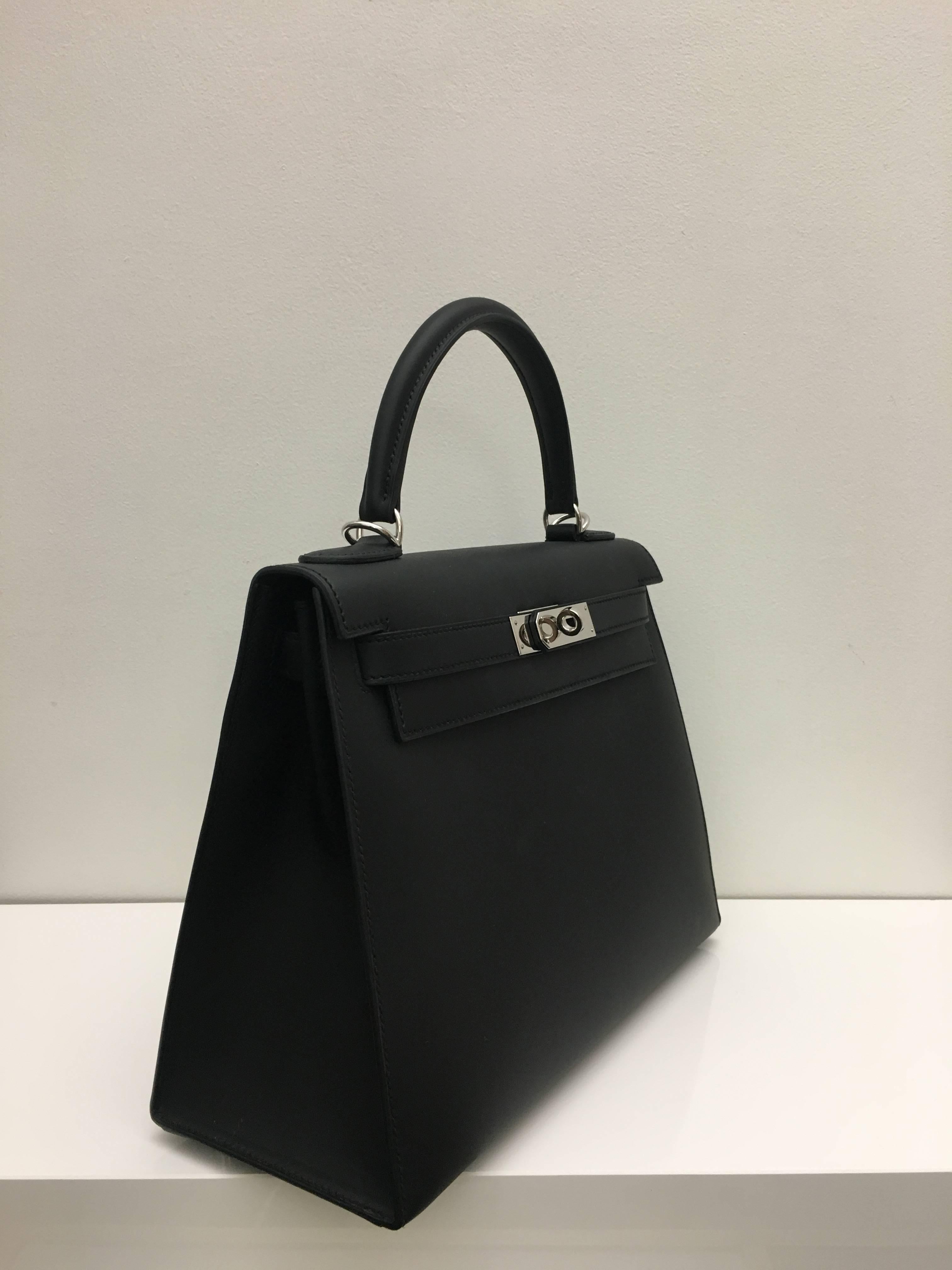 Hermes 
Kelly Size 28
Sobrero Leather 
Colour Black (Noir)
Palladium (Silver) Hardware 
store fresh, comes with receipt and full set (dust bag, box...) 
Hydeparkfashion specializes in sourcing and delivering authentic luxury handbags, mainly