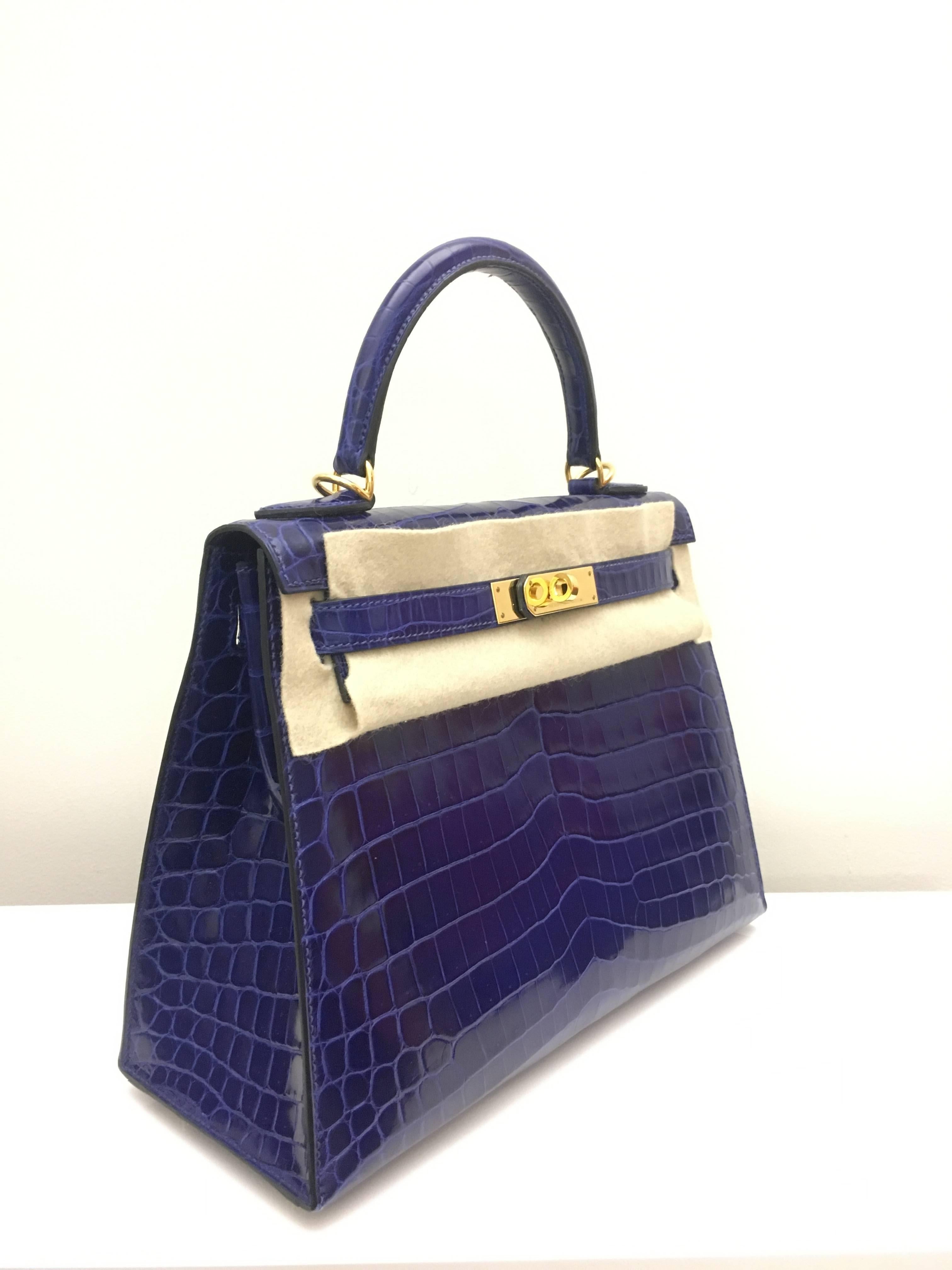 Hermes 
Kelly Size 28
Shiny Croc Leather 
Colour Electric Blue
Gold Hardware 
store fresh, comes with receipt and full set (dust bag, box...) 
Hydeparkfashion specializes in sourcing and delivering authentic luxury handbags, mainly Hermes, to