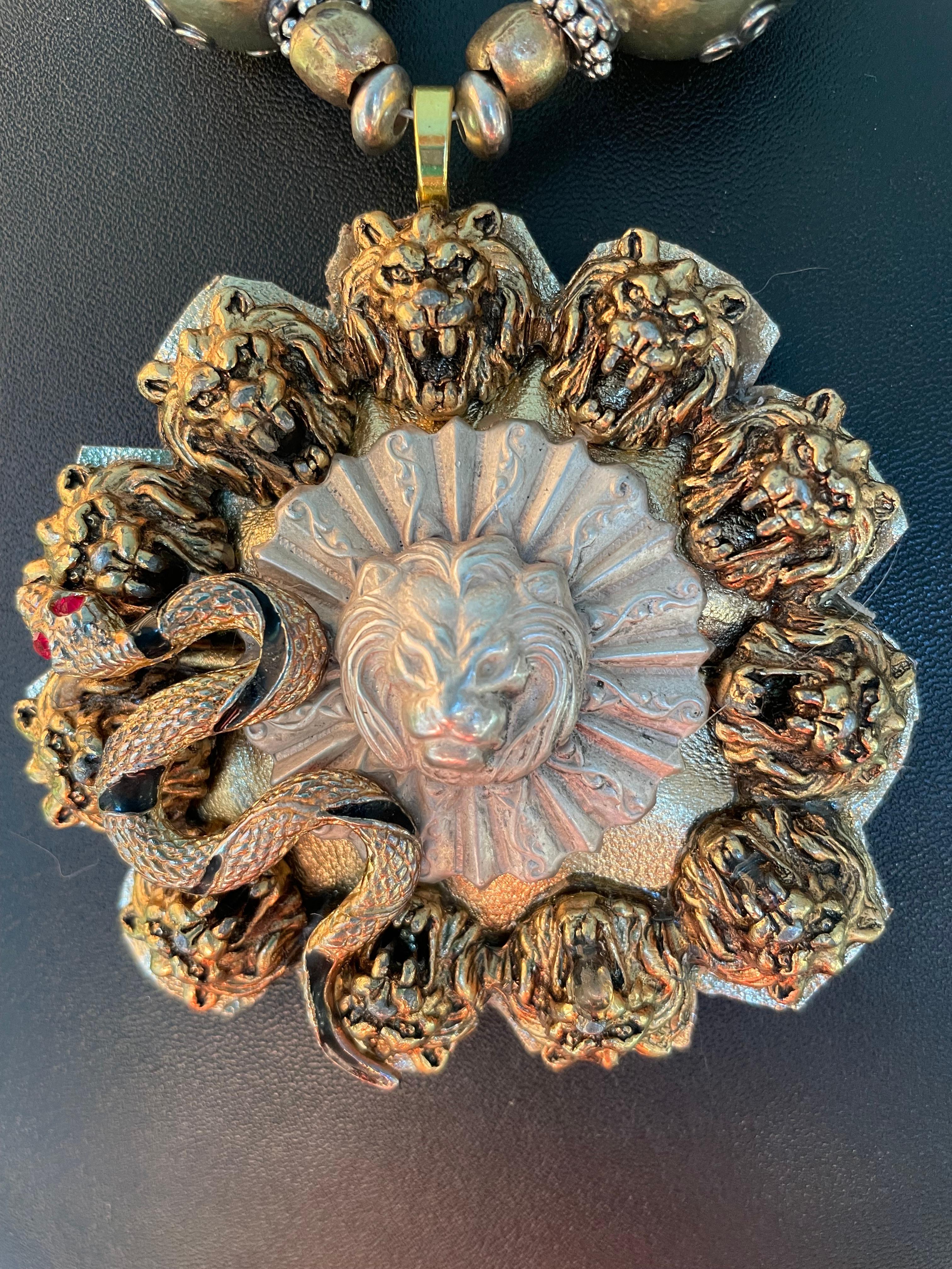 Lorraine's Bijoux tiene en oferta una hebilla circular vintage de latón con cabeza de león, un broche de plata de ley con cabeza de león, un pendiente vintage de latón con forma de serpiente y un soporte de cuero metálico plateado. El tamaño de este