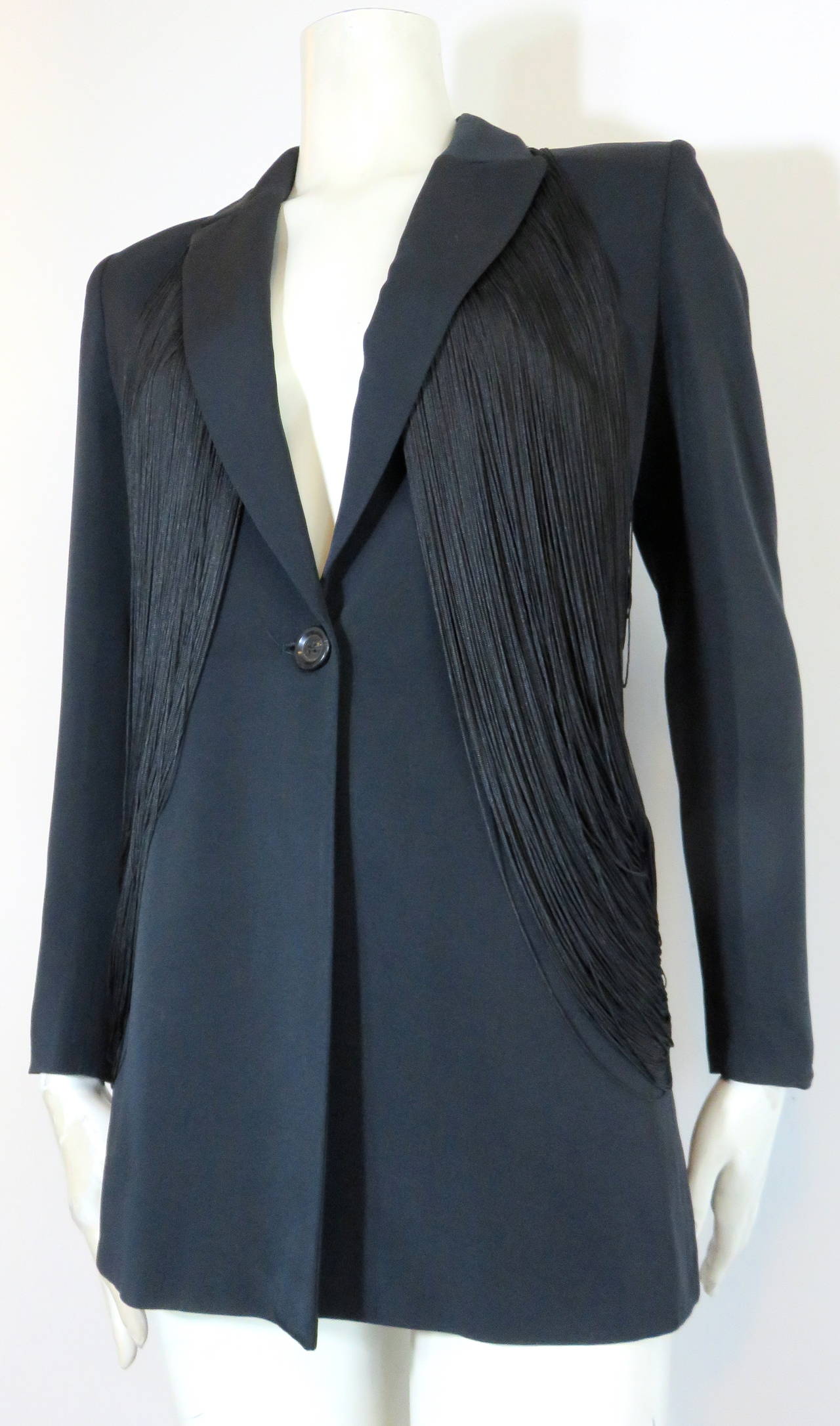 Excellent condition, RIFAT OZBEK Black fringe jacket.

This wonderfully tailored jacket features dramatic, draped, fringe detailing at front to back on both sides.

Sharp, constructed shoulder shape.

Single button front opening.

Fully