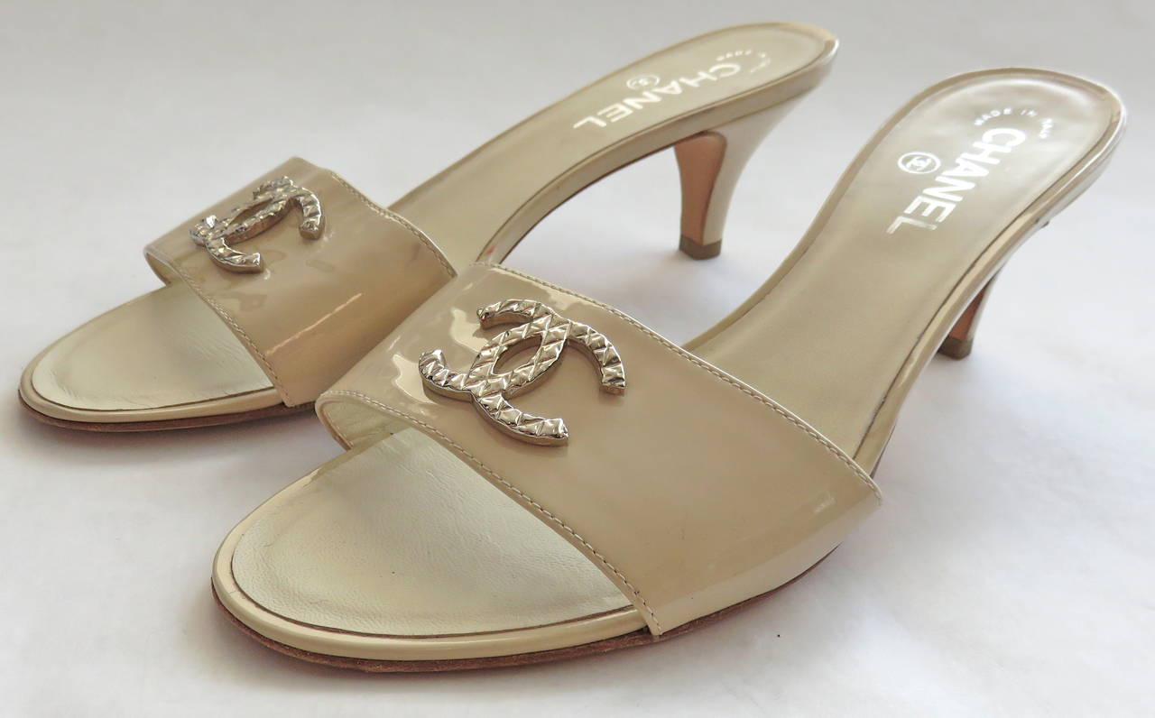 CHANEL PARIS light beige patent leather mules with quilt engraved, metal 'CC' monogram logo fronts.

Leather insoles with metallic silver logo printing.

Made in Italy, as engraved.

100% Authentic guaranteed.

*MEASUREMENTS*

Marked EU