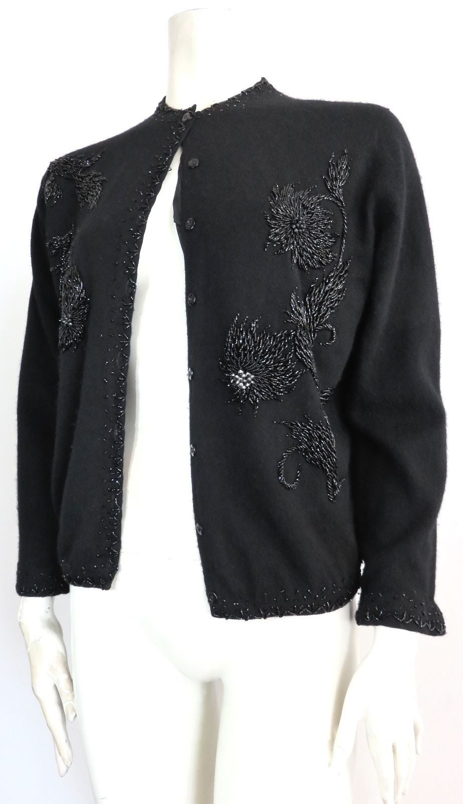 Lovely, 1960's PRINGLE OF SCOTLAND 100% cashmere sweater with gorgeous, floral beading artwork at front and back.

Ultra-plush and soft cashmere knit fabrication with detailed, jet-black hand-beading around edges of cardigan.

Button front