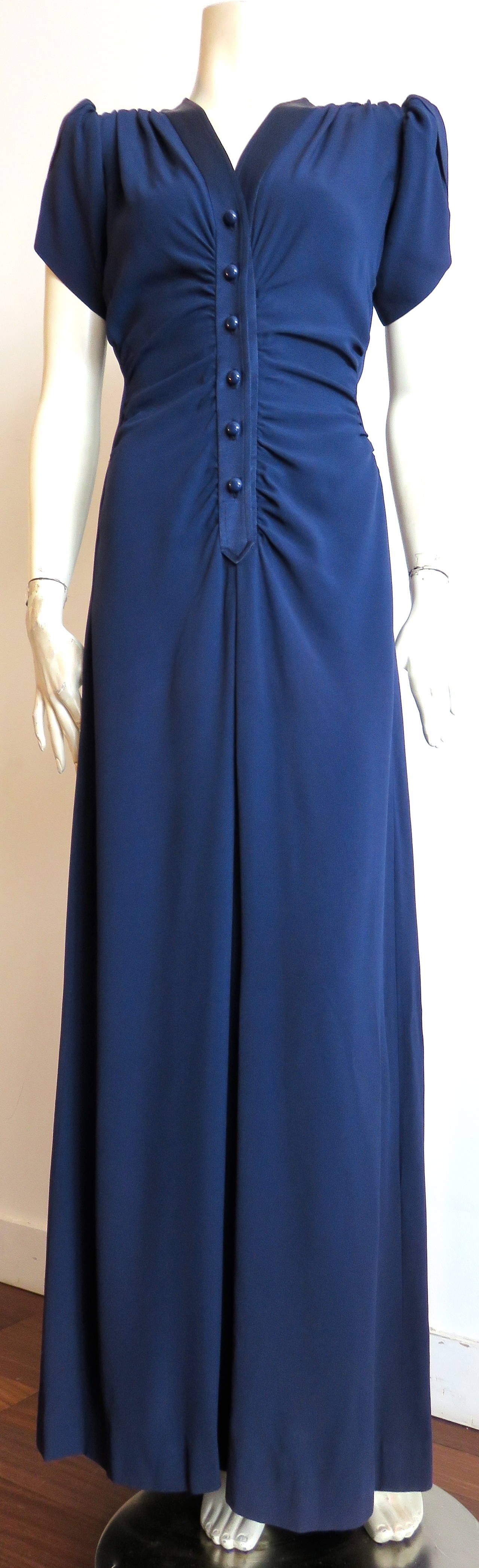 Stunning, 1983 YVES SAINT LAURENT 40's style blue crepe dress.

Mr. Saint Laurent was inspired by the 1940's film 'Gilda' for his 1983 Spring/Summer couture collection.  
 
This classic, 1940's inspired day dress of the same year/season features