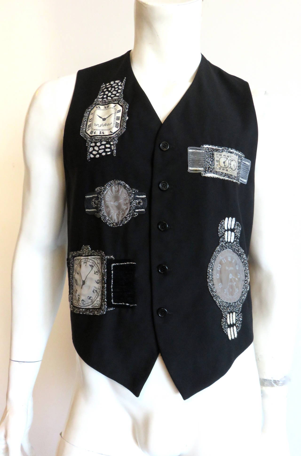 1980's BYBLOS Men's embroidered 'Watch dealer' vest.

This fun vest features black and metallic silver, hand-embroidery with soutache work surrounding jacquard 'Byblos' dial/time faces.  There are also some black, velvet appliqué details as well.