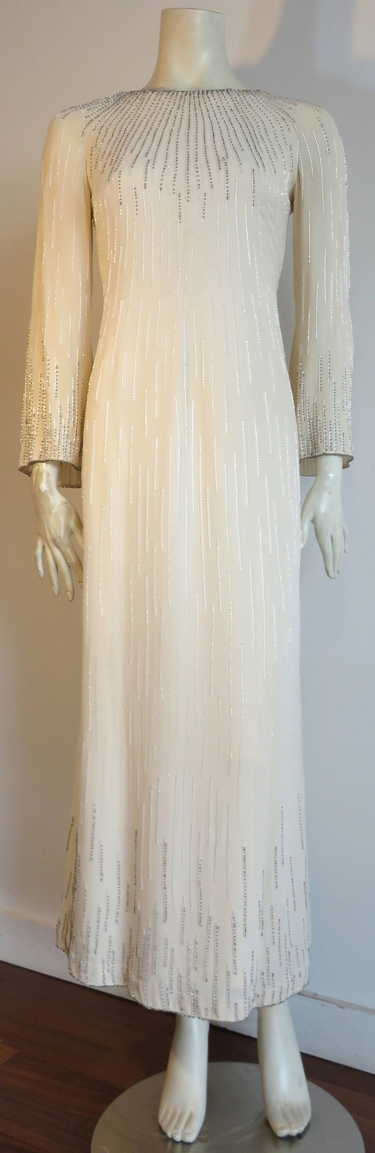 Excellent condition, 1970's GUY LAROCHE Haute Couture beaded evening gown dress.

This stunning dress is made of pure, light creme/ecru silk crepe with all over hand-beading.  The radial beadwork outlines the neckline, sleeve, and bottom