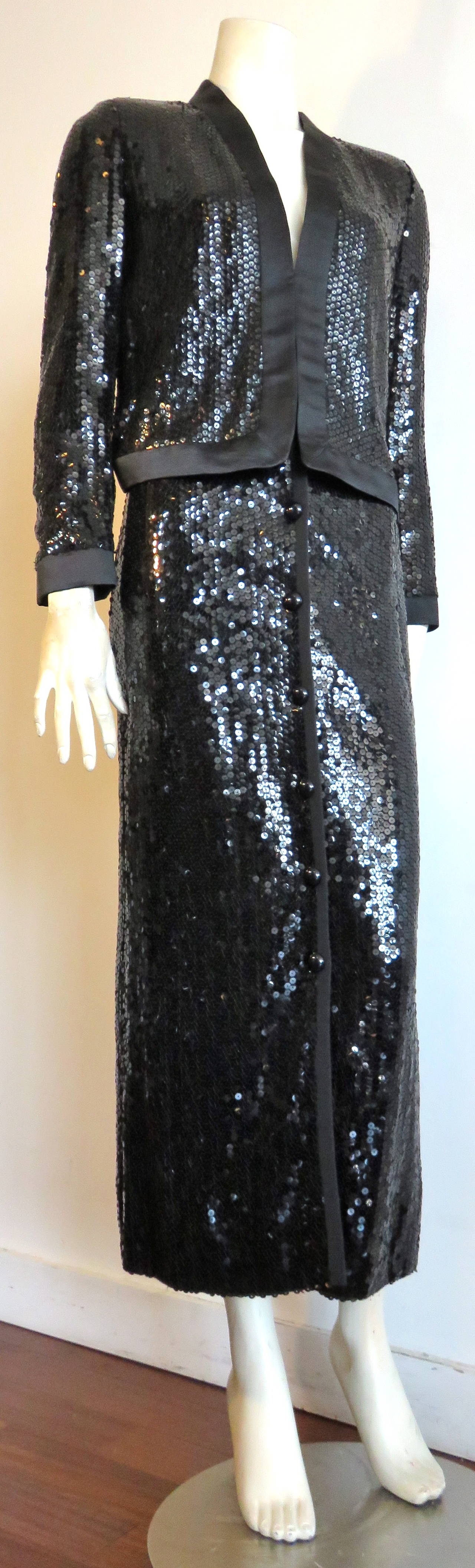 Great condition, 1970's VALENTINO Sparkling black sequin evening set.

This luxurious evening set is comprised of a black sequin jacket with satin trims, and matching long skirt.

The jacket features a cardigan-style silhouette with concealed,