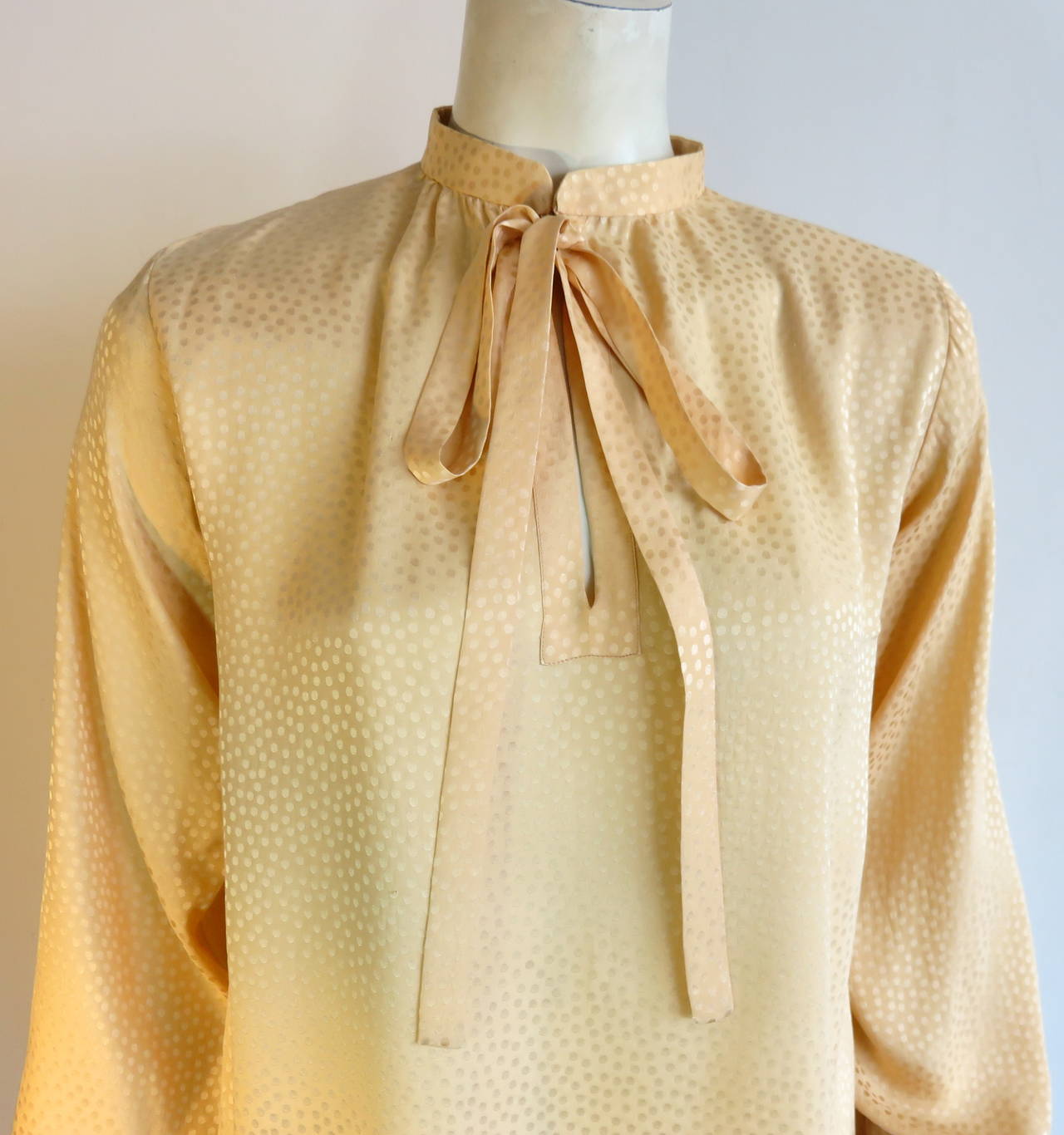 Excellent condition, 1970's YVES SAINT LAURENT 100% silk blouse with dotted jacquard patterning.

Tie front neck detail with split neck opening at center-front.

Made in France.

In excellent condition with no signs of wear or