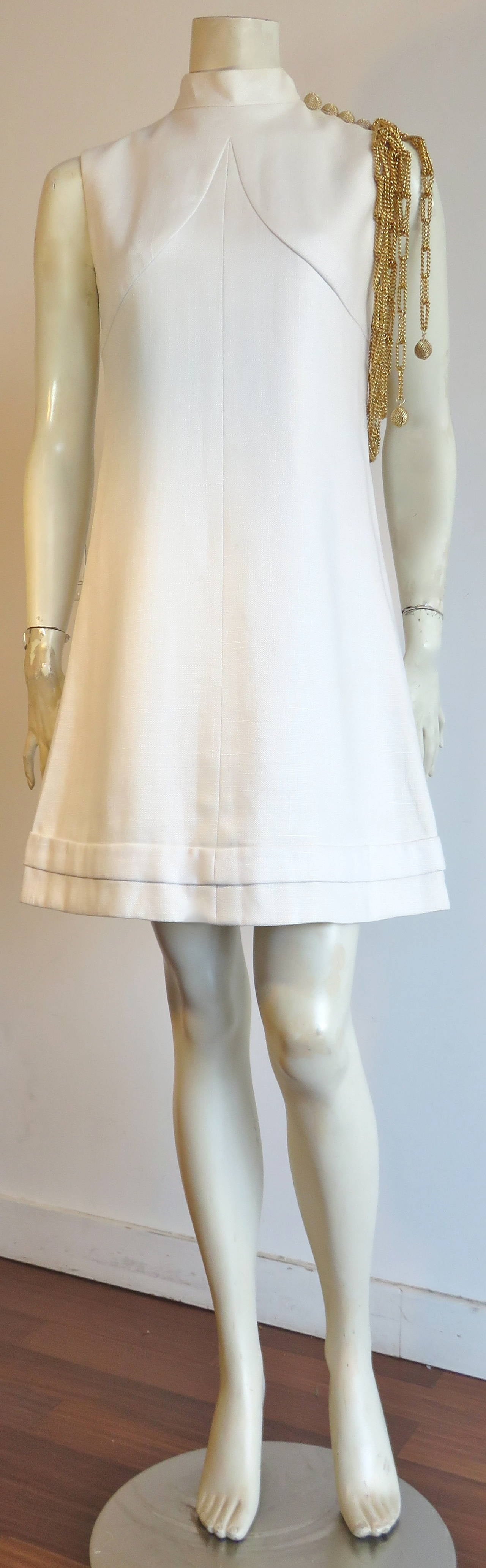 Documented, 1960's BILL BLASS For MAURICE RENTNER Chain detail dress.

The great, white linen day dress includes the original, gold-finished, side shoulder chain detail with ball chain ends.  

The wearer's left shoulder features dome-shaped,