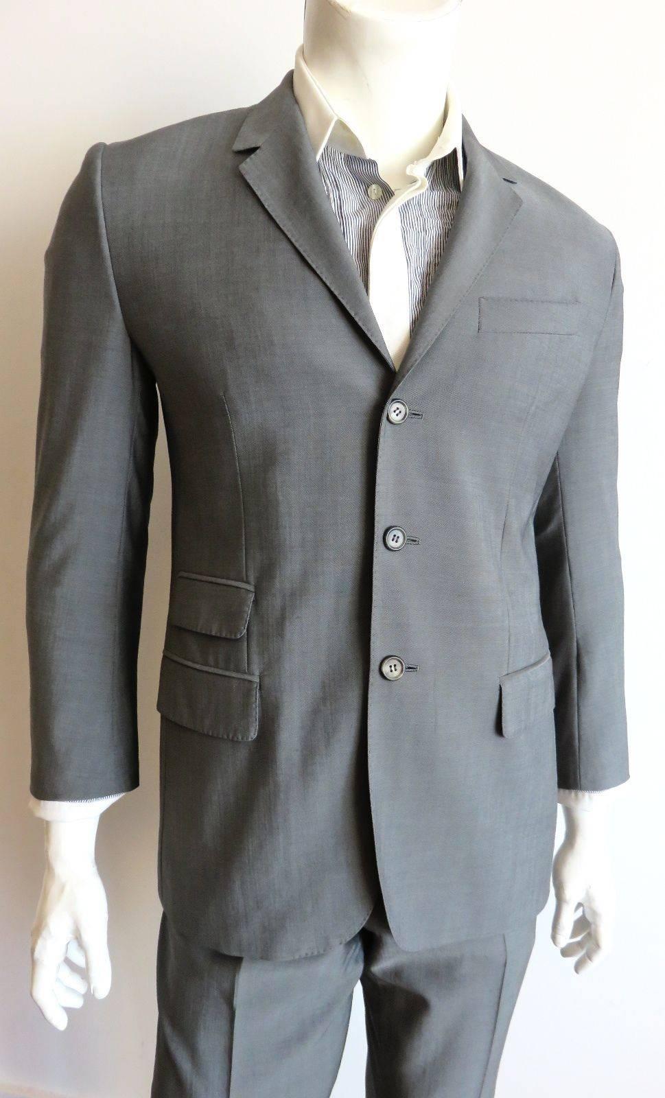 Pre-death, 2004, ALEXANDER MCQUEEN 2pc. suit.

Gorgeous, gray wool fabrication with a nice sheen.

Three-button front with twin waist level flap pockets, and third, ticket pocket detail at the right waist.

Flat front matching pants with